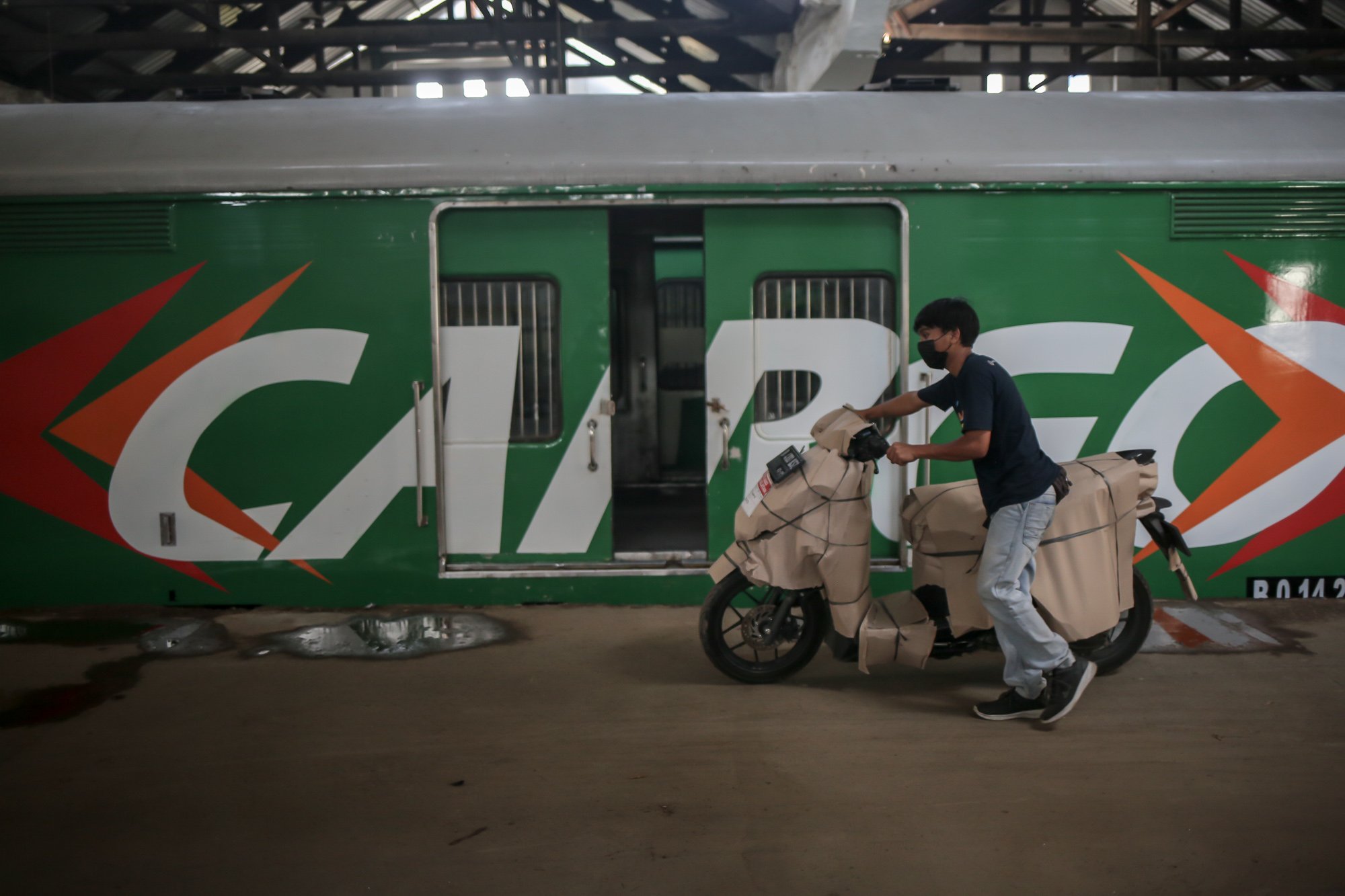 Petugas memindahkan motor yang sudah dikemas untuk dikirim menggunakan kereta di Stasiun Kampung Bandan, Jakarta Utara, Selasa (26/4/2022). PT Kereta Api Indonesia (KAI) Logistik (Kalog) menyediakan 9.280 kuota pengiriman motor gratis selama arus mudik dan arus balik Lebaran 2022.