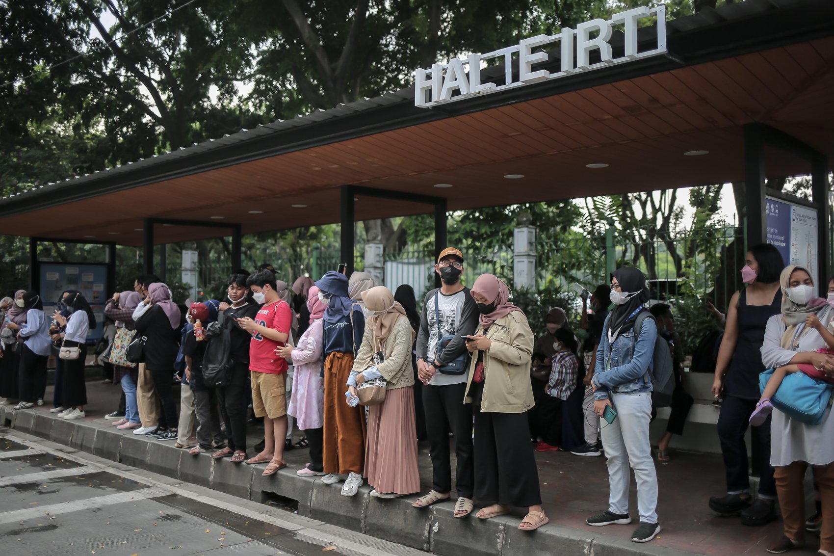 Warga menunggu bus wisata terbuka untuk menikmati suasana kota dari atas Jakarta di Halte Irti, Selasa, (10/5/2022). PT Transportasi Jakarta (Transjakarta) memfasilitasi layanan bus wisata gratis selama libur lebaran 2022.