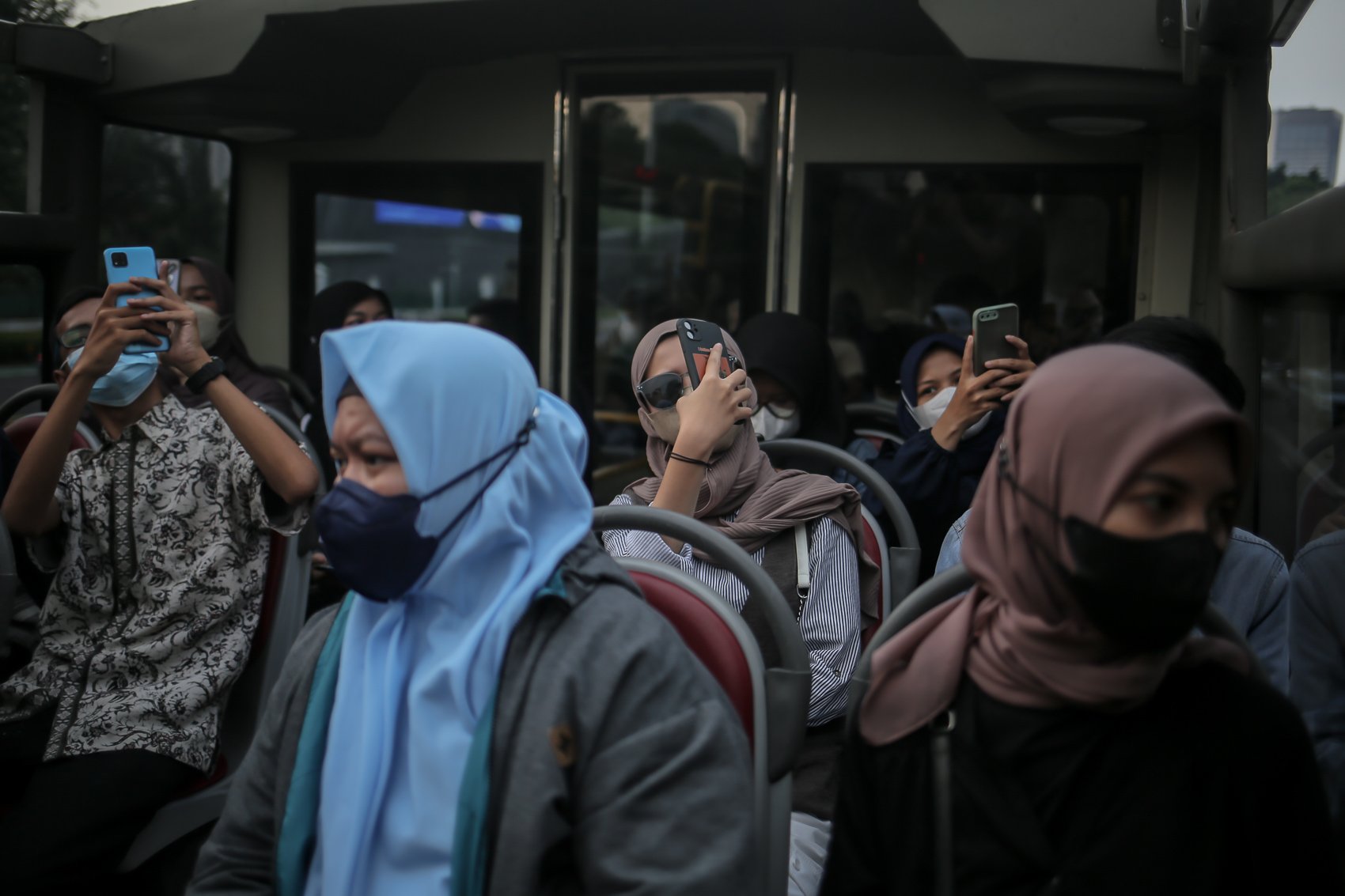 Warga merekam suasana kota saat menaiki bus wisata gratis di Jakarta, Selasa, (10/5/2022). PT Transportasi Jakarta (Transjakarta) memfasilitasi layanan bus wisata gratis selama libur lebaran 2022.
