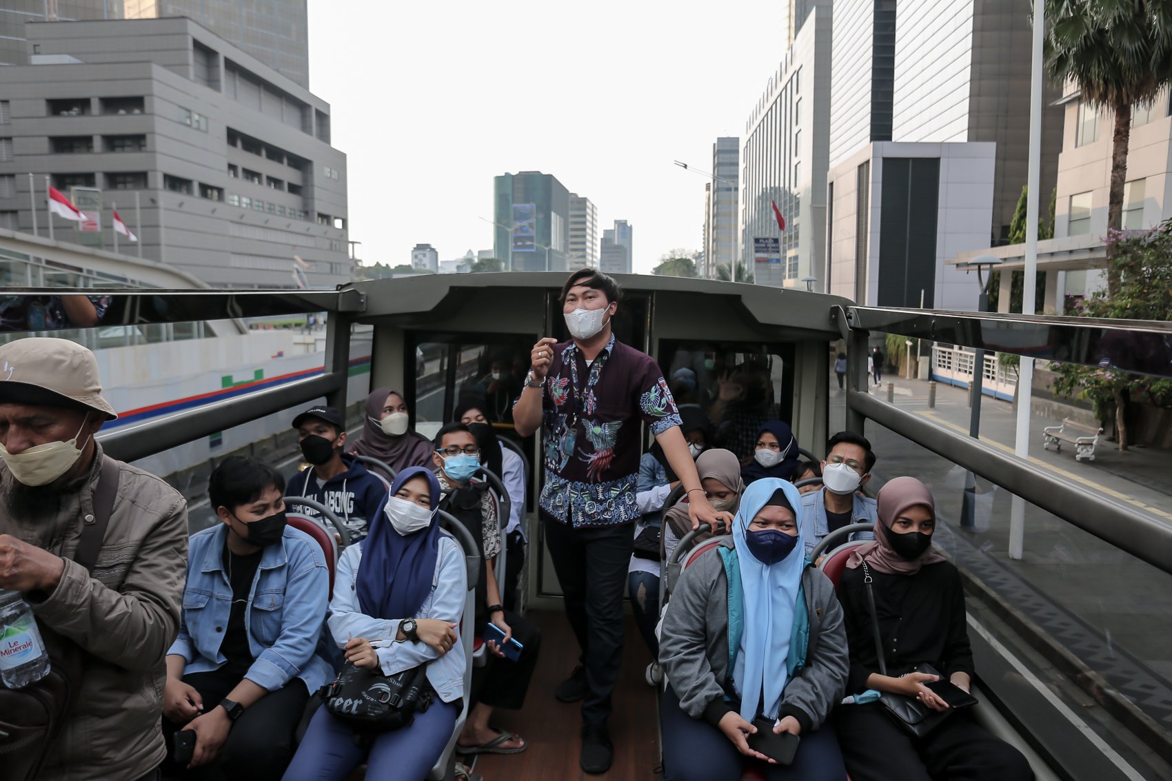 Pemandu bus wisata terbuka melayani penumpang saat menikmati suasana kota dari atas Jakarta, Selasa, (10/5/2022). PT Transportasi Jakarta (Transjakarta) memfasilitasi layanan bus wisata gratis selama libur lebaran 2022.