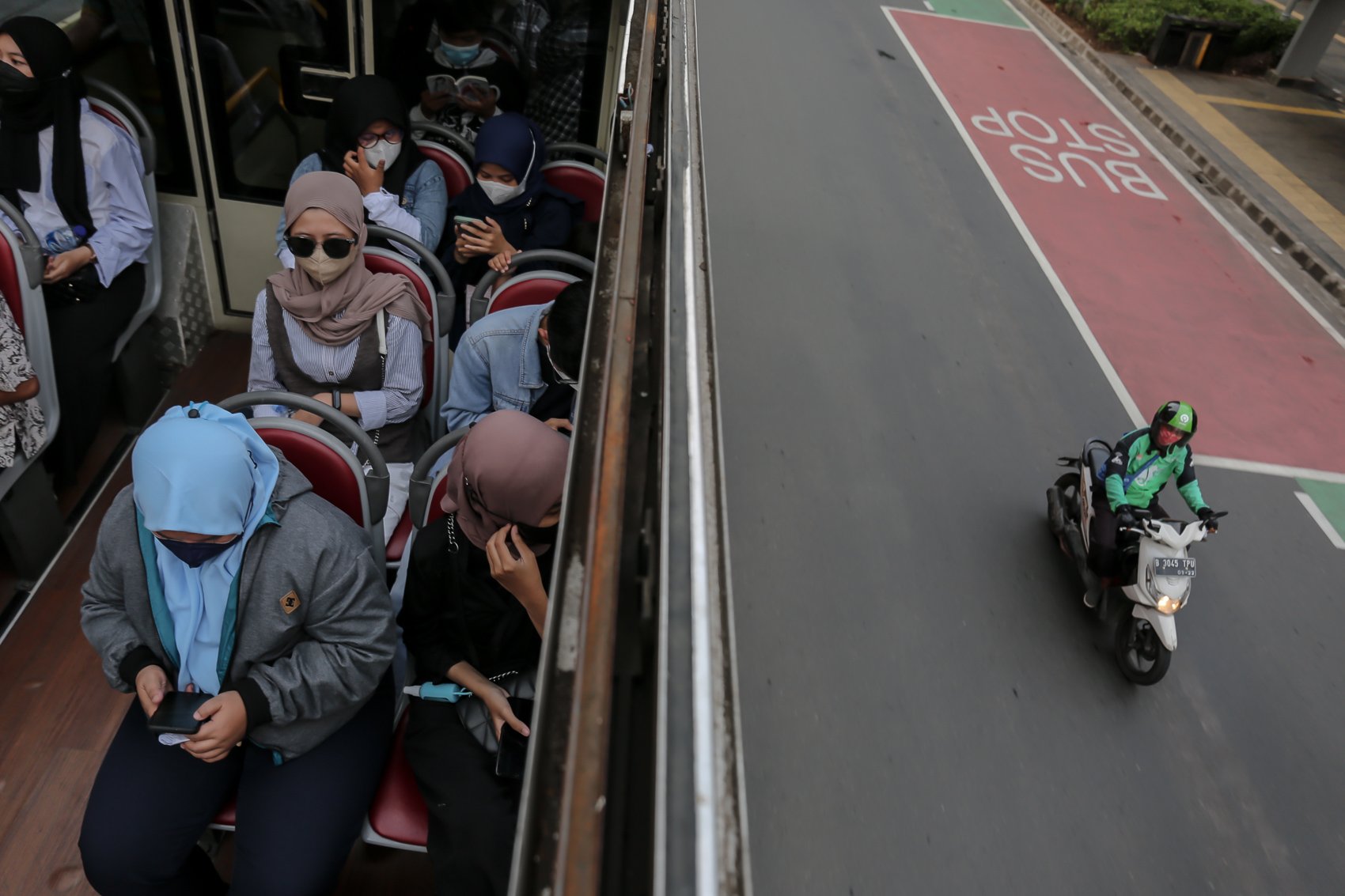Warga menaiki bus wisata terbuka untuk menikmati suasana kota dari atas di Jakarta, Selasa, (10/5/2022). PT Transportasi Jakarta (Transjakarta) memfasilitasi layanan bus wisata gratis selama libur lebaran 2022.
