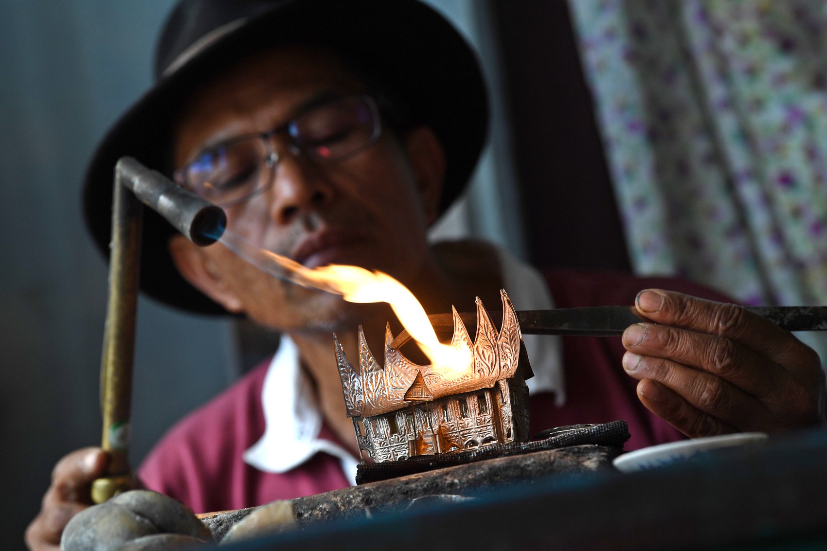 Pengrajin Muhammad Iskandar memproduksi kerajinan perak di bengkel kerja sekaligus galeri Silver Cici, sentra kerajinan perak Nagari Koto Gadang, Kabupaten Agam, Sumatera Barat.