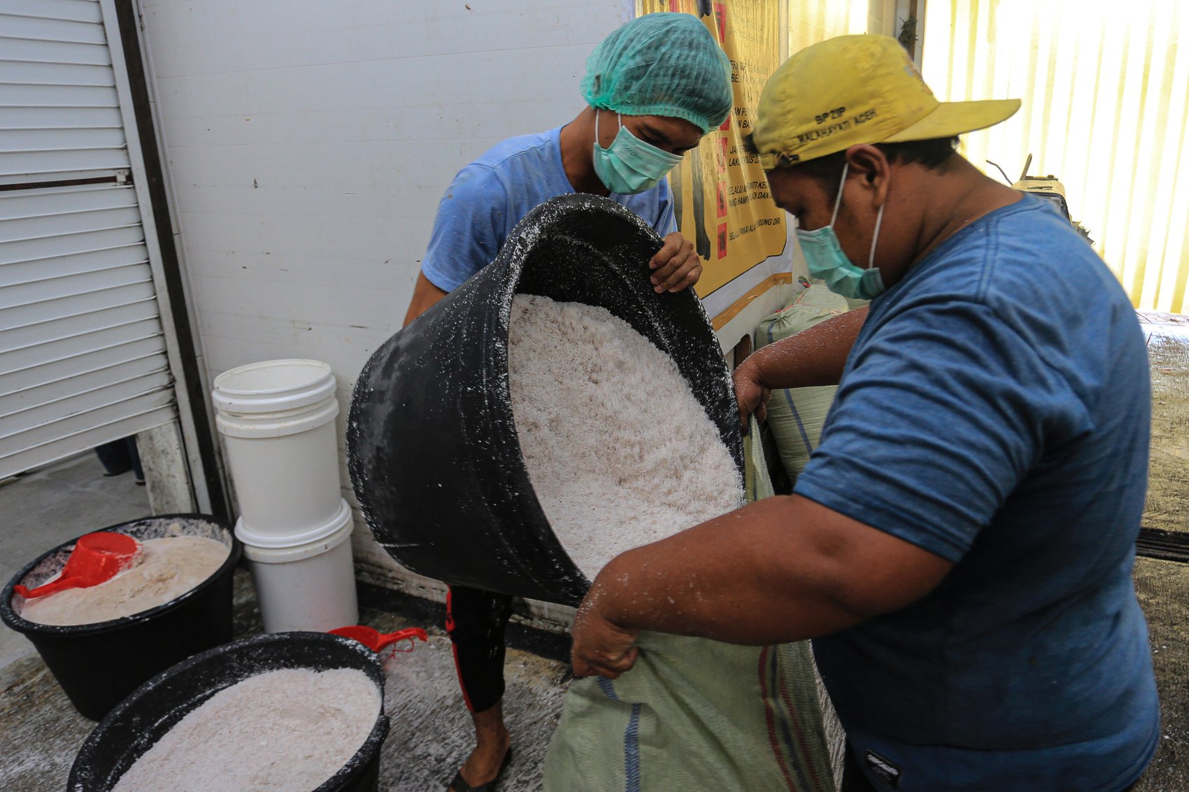 Pekerja mengumpulkan ampas buah kelapa usai proses pengambilan inti santan untuk pembuatan minyak kelapa murni