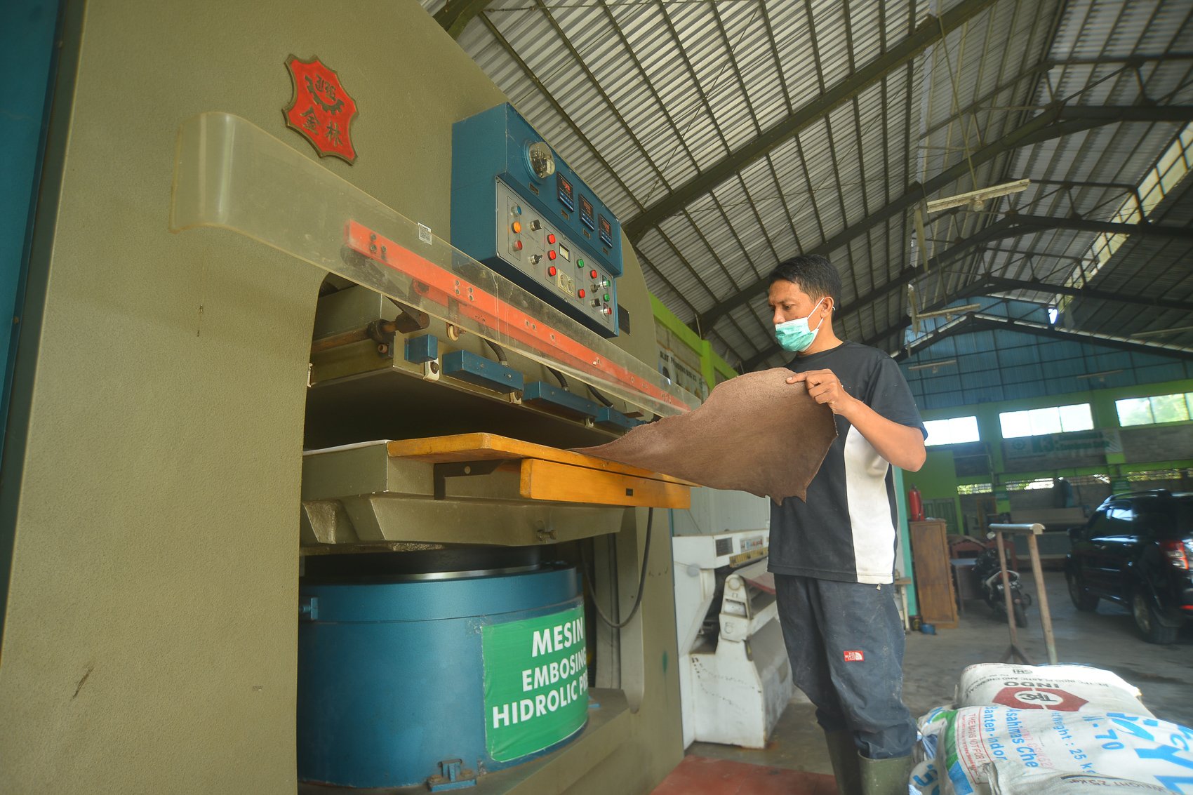Pekerja menyelsaikan proses penyetakan motif sesuai pesanan pada kulit sapi di Unit Pelayanan Teknis Daerah (UPTD) Pengolahan Kulit, Kota Padang, Sumatera Barat.