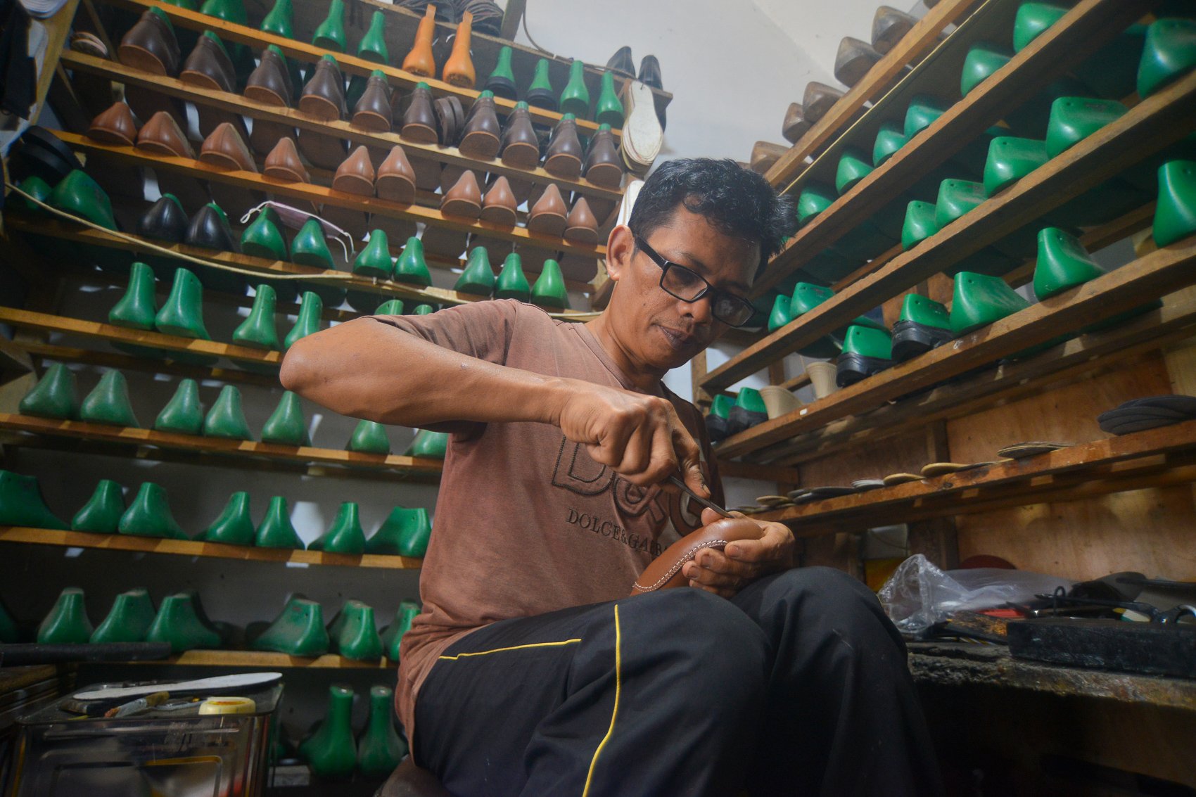Pekerja menyelesaikan peroses pembuatan sepatu kulit di rumah produksi Minang Kayo, Padang Panjang, Sumatera Barat.
