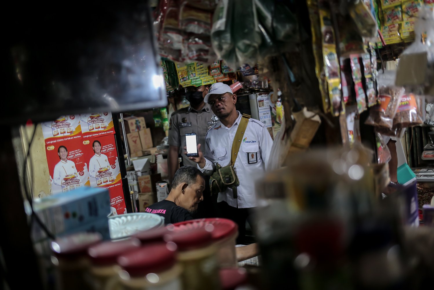 Petugas melakukan sosialisasi perubahan sistem penjualan dan pembelian minyak goreng curah dengan menggunakan PeduliLindungi kepada pedagang di Pasar Kebayoran Lama, Jakarta, Senin (27/6). Menteri Koordinator Bidang Kemaritiman dan Investasi Luhut Binsar Pandjaitan mengatakan perubahan sisten ini untuk memantau dan mengawasi distribusi komoditas itu dari produsen ke konsumen.