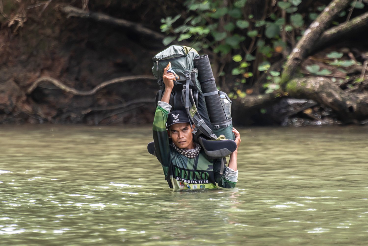 Anggota Monitoring Badak Jawa (MBJ) menyebrangi aliran sungai Cibunar di Taman Nasional Ujung Kulon, Banten.