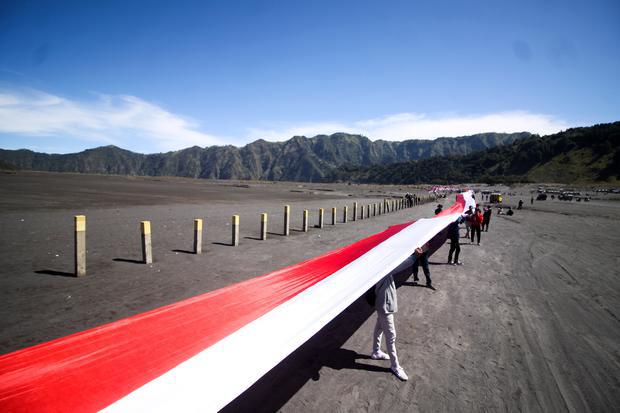 Puluhan pengunjung membentangkan bendera Merah Putih sepanjang 2022 meter di Kawasan Gunung Bromo, Probolinggo, Jawa Timur, Rabu (17/8/2022). Kain yang terbagi dalam sejumlah potongan dan disatukan menjadi bendera Merah Putih raksasa sepanjang 2022 meter tersebut dibentangkan untuk memperingati HUT ke-77 kemerdekaan RI.