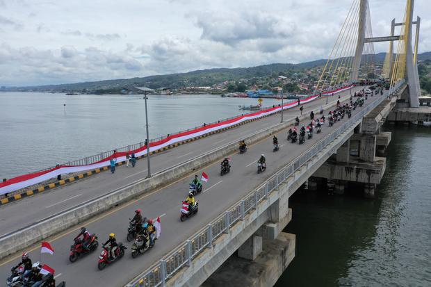 Foto udara pembentangan bendera Merah Putih di Jembatan Teluk Kendari, Kendari, Sulawesi Tenggara, Rabu (17/8/2022). Mahasiswa Universitas Muhammadiyah Kendari (UMK) bersama pelajar dan warga membentangkan bendera sepanjang 770 meter di atas Jembatan Teluk Kendari untuk memperingati HUT ke-77 Kemerdekaan RI.