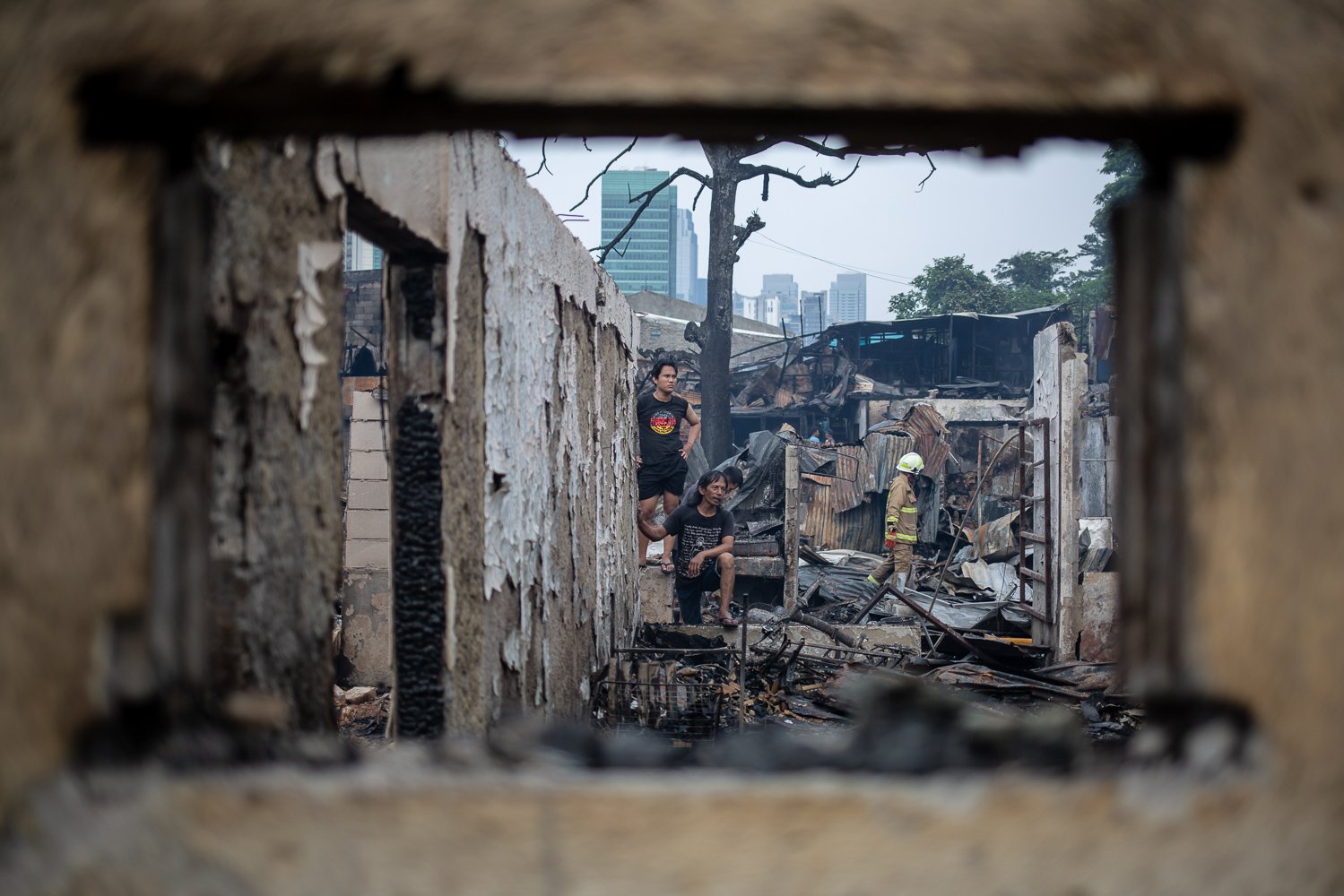 Suku Dinas Penanggulangan Kebakaran dan Penyelamatan (Gulkarmat) dan warga mengamati sejumlah rumah di pemukiman padat penduduk yang hangus dilahap si jago merah di Jalan Simprug Golf II, Kecamatan Kebayoran Lama, Jakarta, Minggu (21/8). Akibat peristiwa tersebut 1 orang meninggal dunia diduga akibat kaget dan kelelahan. Selain itu, sebanyak 383 jiwa dari 164 KK harus mengungsi di tenda darurat.