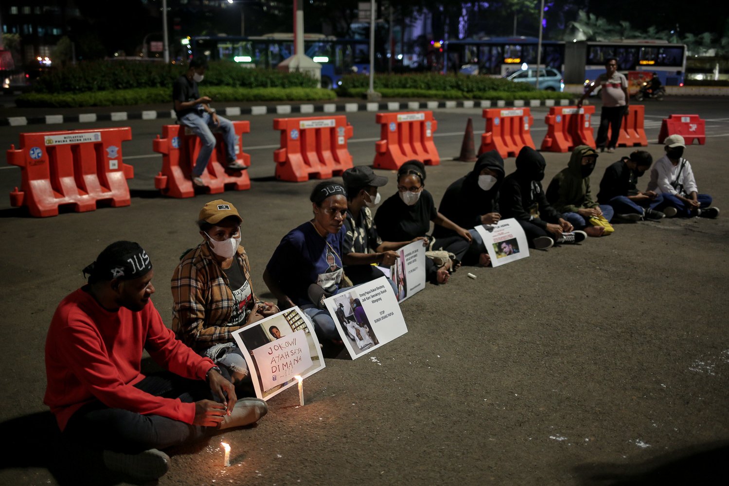 Massa yang tergabung dalam Front Mahasiswa Papua Peduli Korban Kekerasan memegang poster dan lilin saat berunjuk rasa di wilayah Patung Kuda, Jakarta, Jumat (16/9). Aksi seribu lilin tersebut dilakukan untuk solidaritas terhadap 4 korban mutilasi di Timika, Papua.