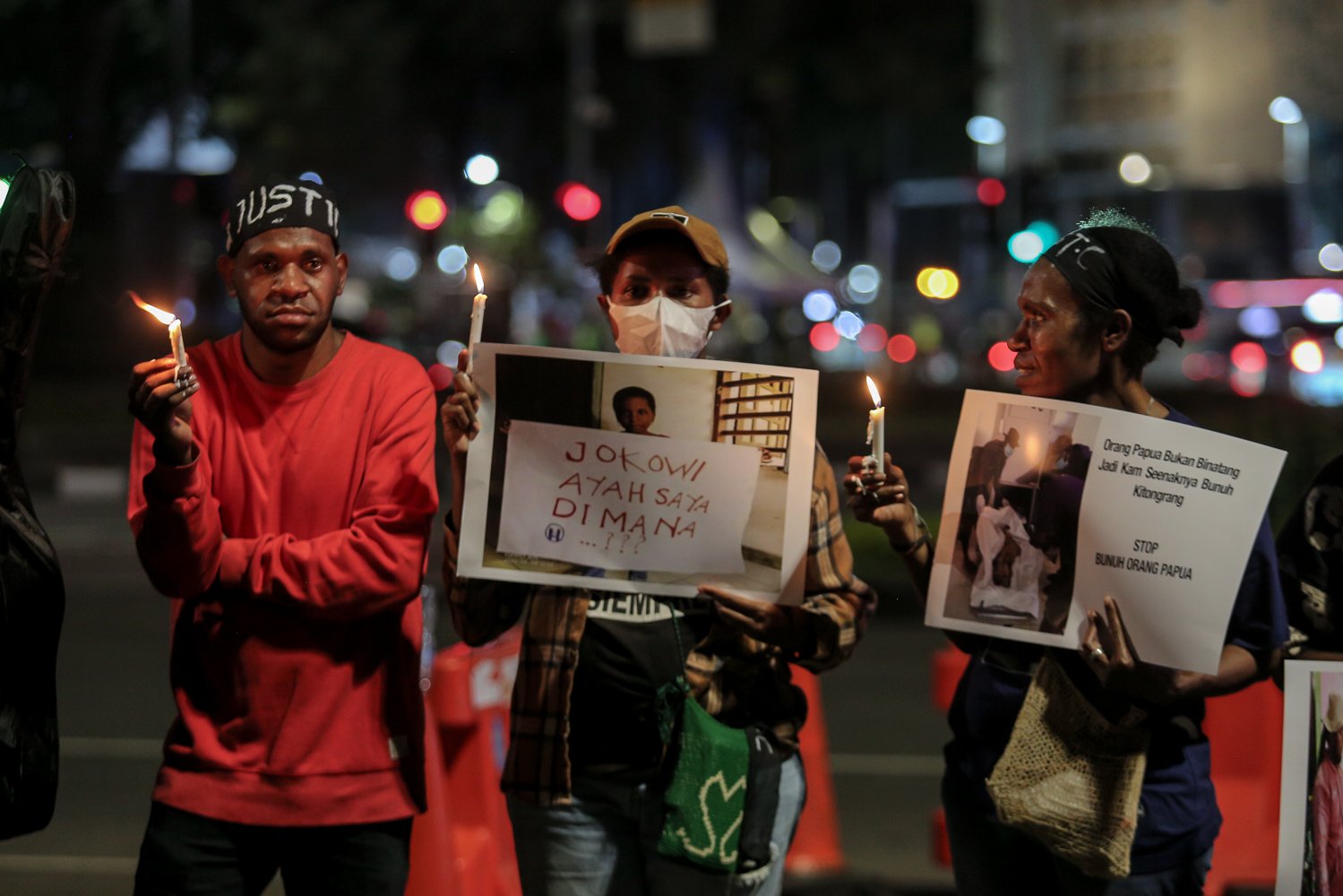 Massa yang tergabung dalam Front Mahasiswa Papua Peduli Korban Kekerasan memegang poster dan lilin saat berunjuk rasa di wilayah Patung Kuda, Jakarta, Jumat (16/9). Aksi seribu lilin tersebut dilakukan untuk solidaritas terhadap 4 korban mutilasi di Timika, Papua.