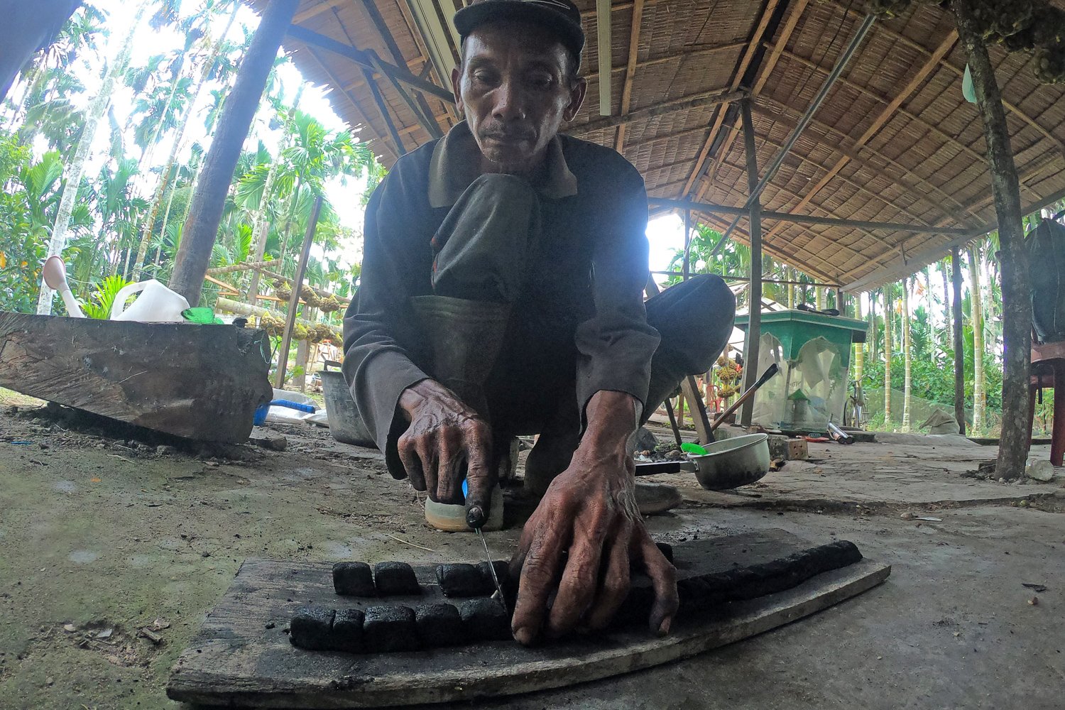 Guntoro memotong cetakan briket setengah jadi usai pengadukan.