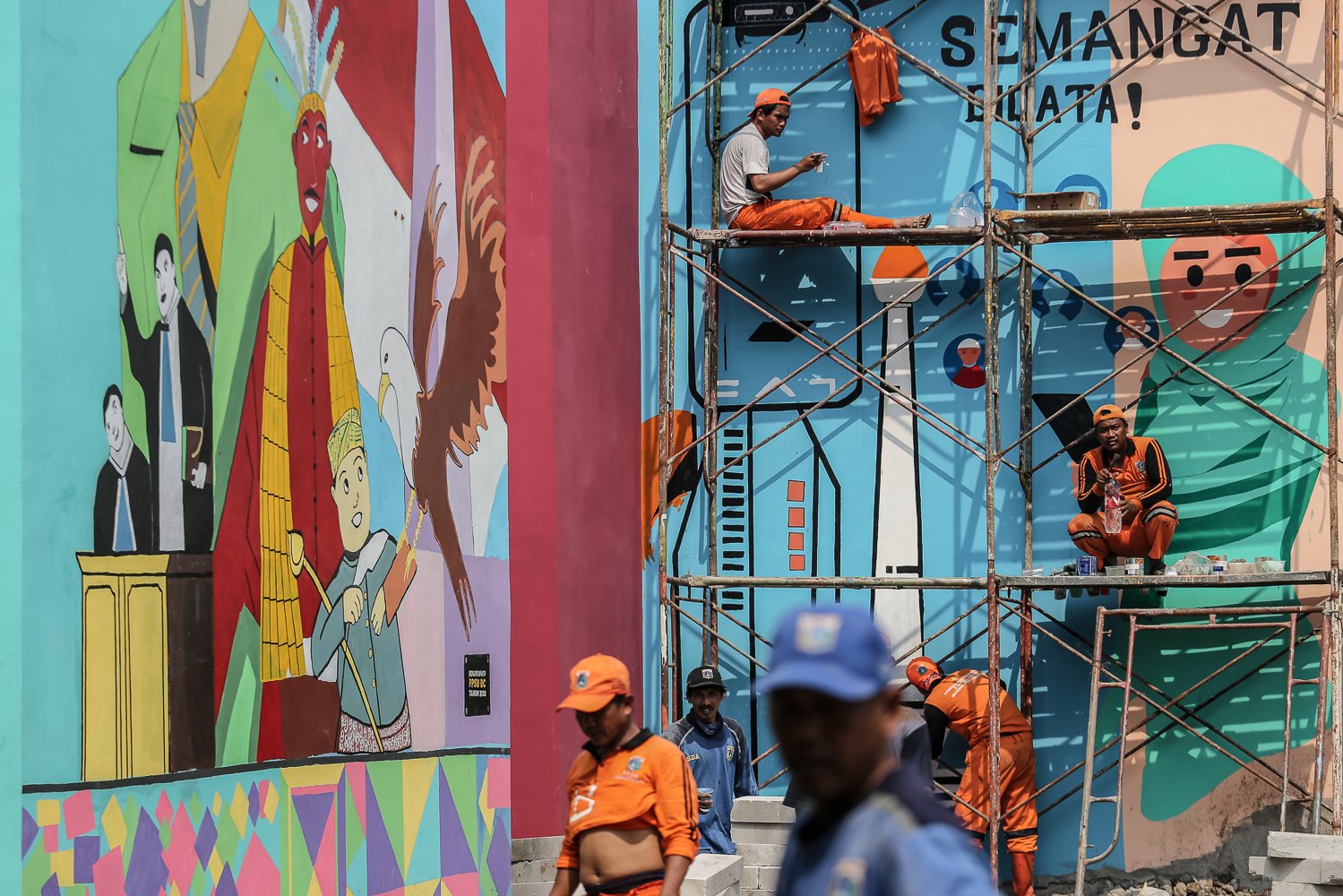 Sejumlah petugas Penanganan Prasarana & Sarana Umum (PPSU) menyelesaikan pembuatan mural di Kampung Gembira Gembrong, Jakarta Timur, Senin (19/9). Menurut data Pemprov DKI Jakarta pembangunan 138 unit rumah bagi korban kebakaran di permukiman Kampung Gembira Gembrong telah mencapai 90 persen dan siap dihuni kembali pada akhir September mendatang.