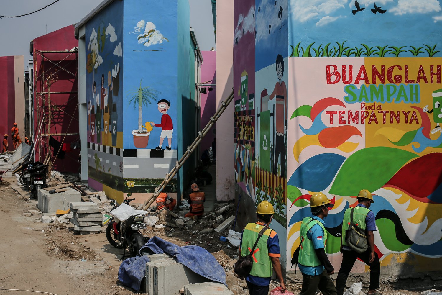 Sejumlah petugas Penanganan Prasarana & Sarana Umum (PPSU) menyelesaikan pembuatan mural di Kampung Gembira Gembrong, Jakarta Timur, Senin (19/9). Menurut data Pemprov DKI Jakarta pembangunan 138 unit rumah bagi korban kebakaran di permukiman Kampung Gembira Gembrong telah mencapai 90 persen dan siap dihuni kembali pada akhir September mendatang.