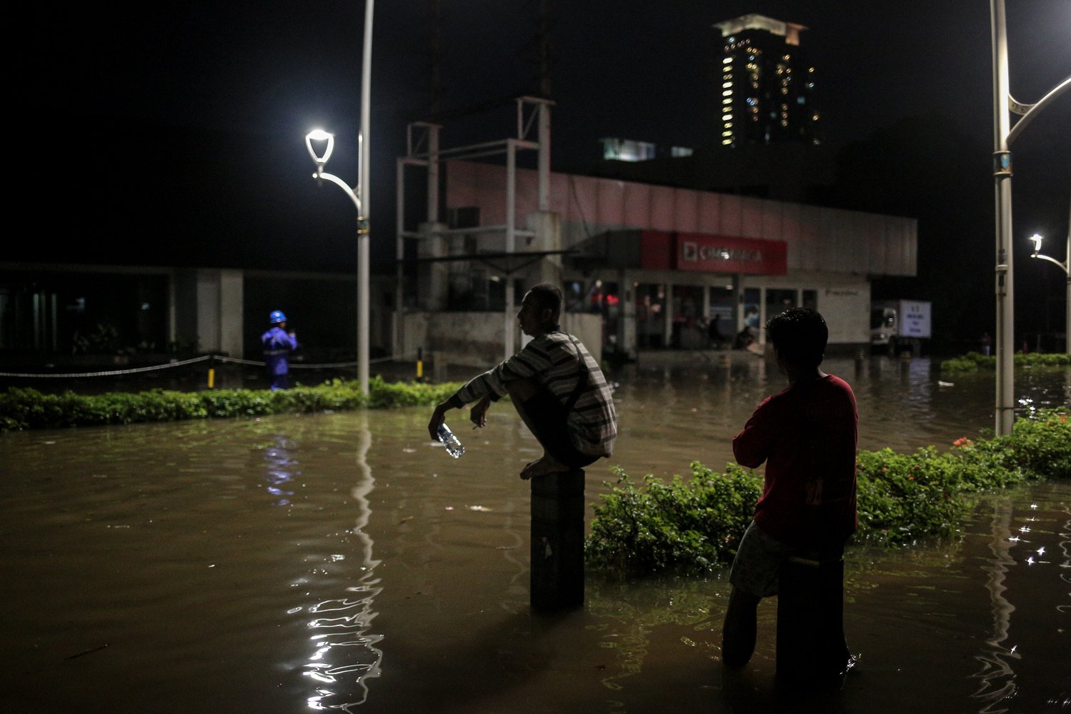 Sejumlah warga duduk diatas tiang saat banjir di Jalan Kemang Raya, Jakarta Selatan, Selasa (4/10). Hujan lebat yang mengguyur DKI Jakarta menyebabkan sejumlah wilayah di Ibu Kota terendam banjir.