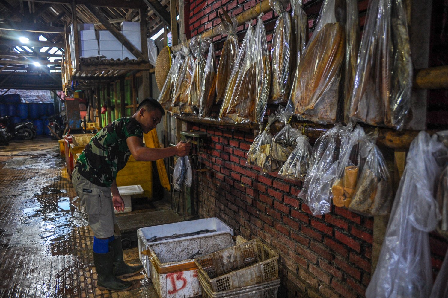Nelayan menyimpan ikan di kotak pendingin di tempat penjualan ikan wilayah Pameungpeuk, Kabupaten Garut.