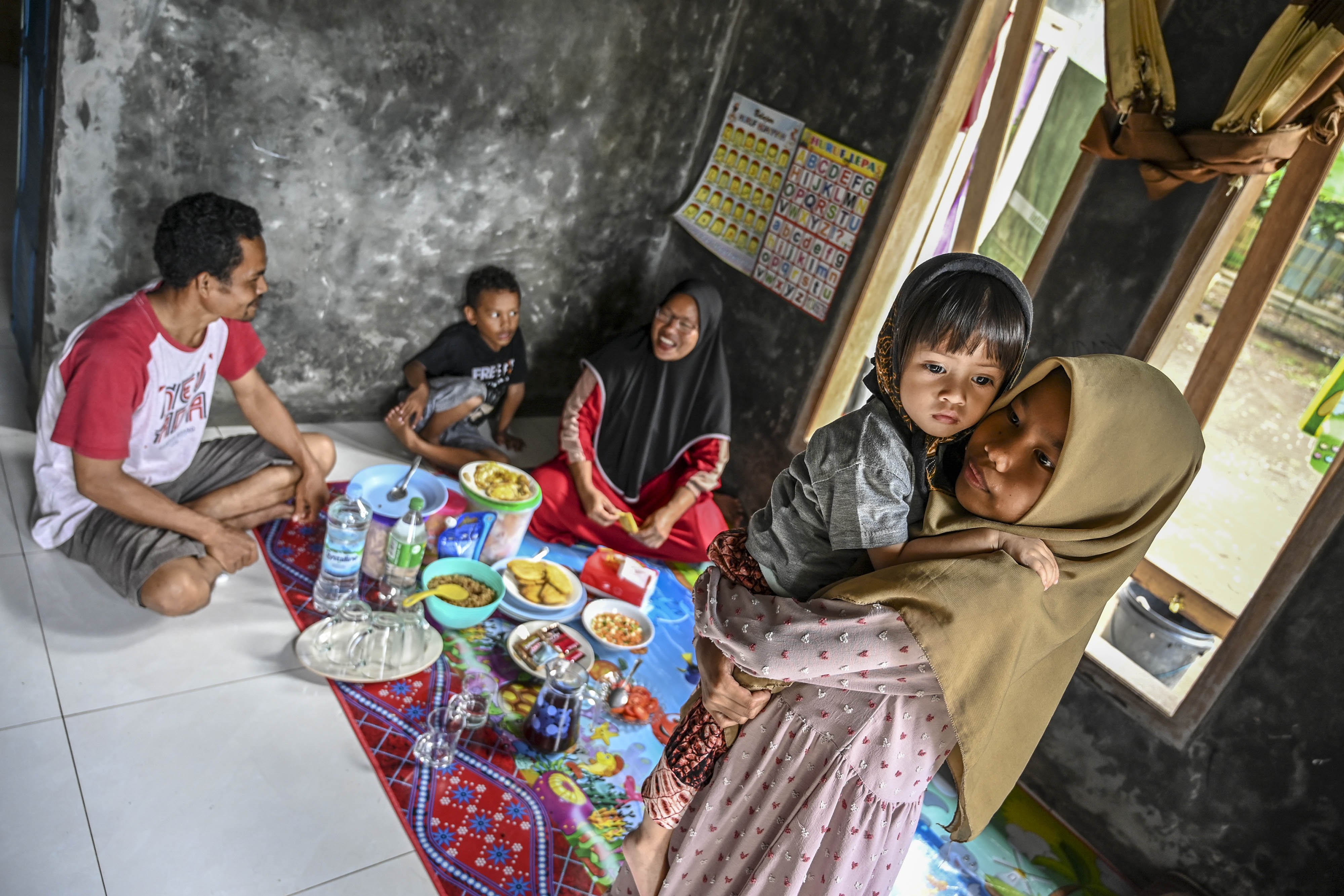 Nurdin, porter asal Desa Ujung Jaya makan bersama keluarganya usai mendampingi tamu ke dalam kawasan Taman Nasional Ujung Kulon di Pandeglang, Banten.