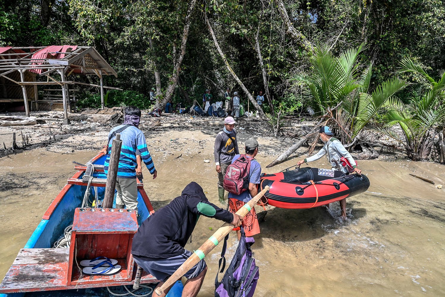 Sejumlah porter mengangkat perlengkapan saat mendampingi tamu yang hendak masuk ke dalam kawasan Taman Nasional Ujung Kulon di Pandeglang, Banten.