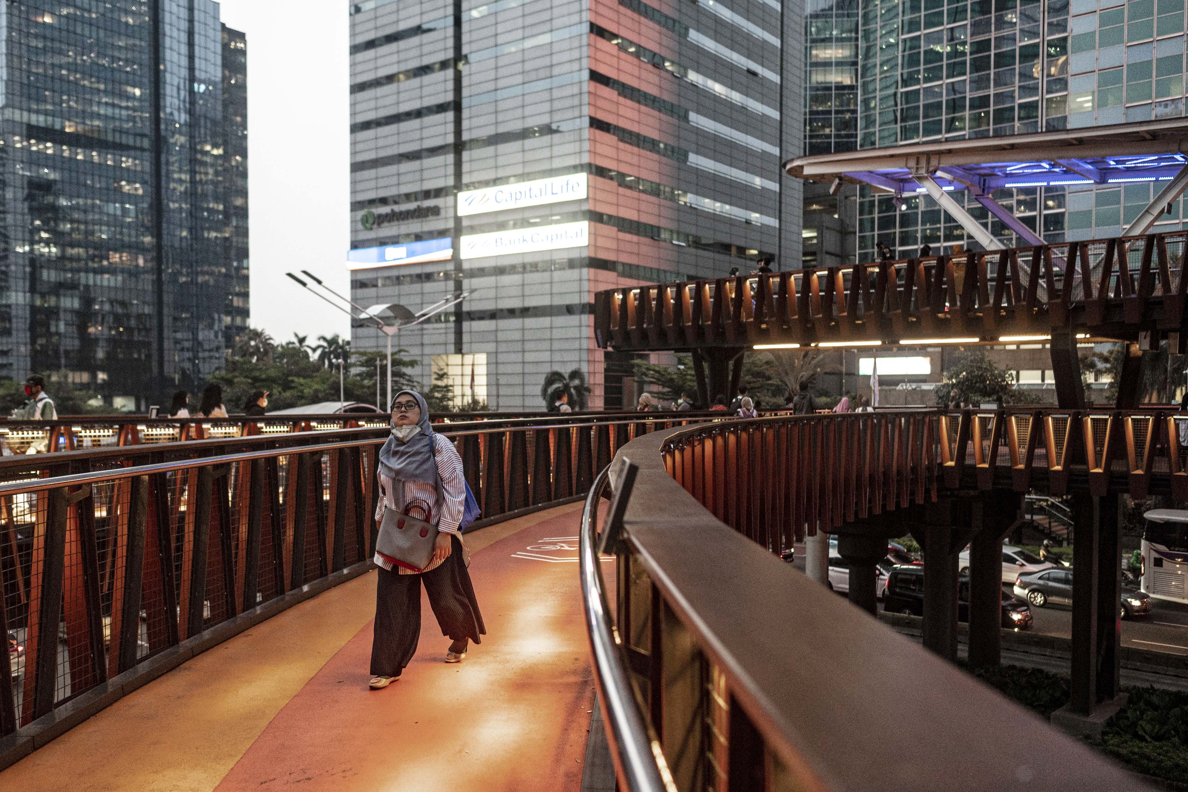 Seorang warga berjalan di saat jam pulang kerja di Jembatan Penyebrangan Orang (JPO) Pinisi, Jakarta