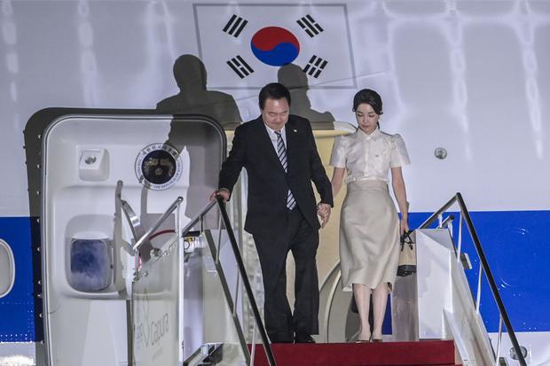 Presiden Korea Selatan Yoon Suk-yeol (kiri) bersama istri Kim Keon Hee (kanan) tiba di terminal VVIP I Bandara I Gusti Ngurah Rai Bali, Minggu (13/11/2022). Kedatangan Presiden Korea Selatan tersebut untuk mengikuti KTT G20 yang akan berlangsung pada 15-16 November.