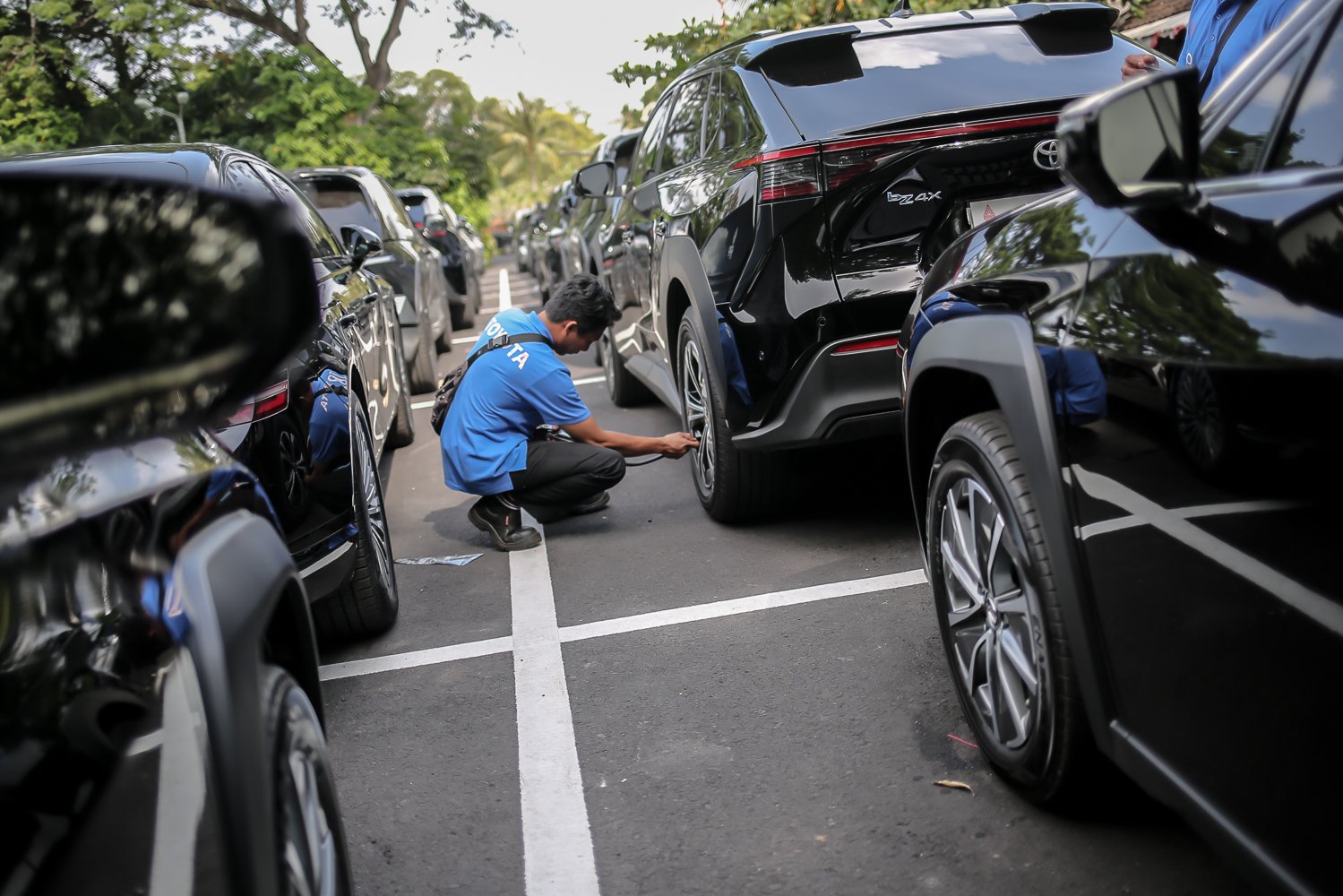Petugas mengisi angin ban mobil listrik Toyota bZ4X di pool mobil listrik Bali Collection, Nusa Dua, Bali, Selasa (15/11). Toyota turut mendukung pemerintah dengan mengirimkan sedikitnya 143 mobil listrik di ajang KTT G20.\r\n\r\n