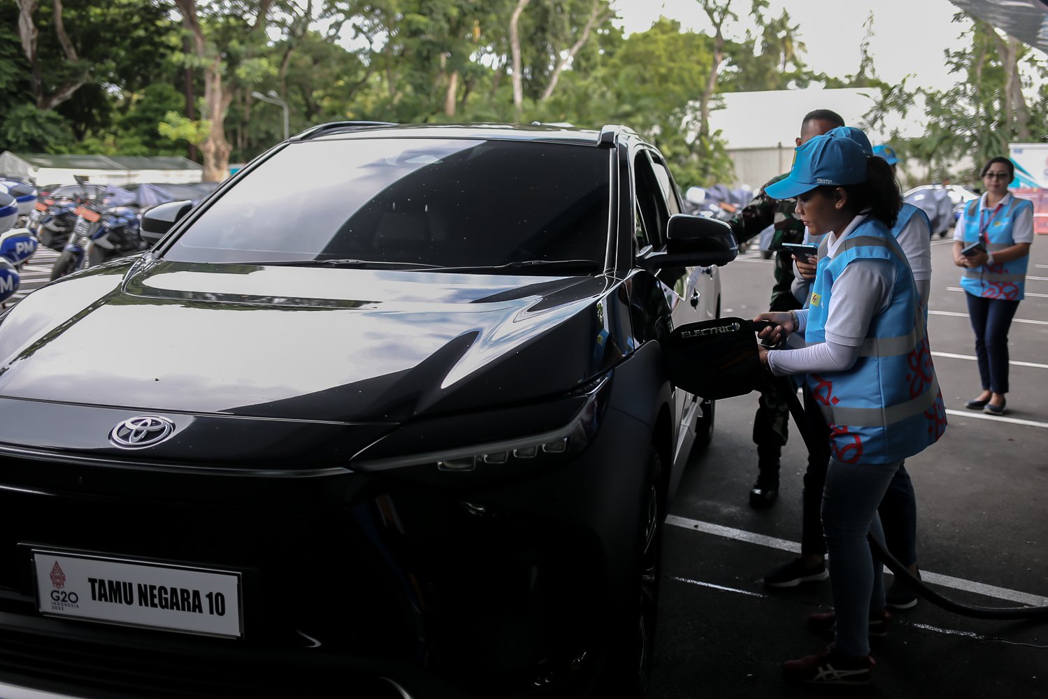 Petugas mengisi daya baterai mobil listrik Toyota bZ4X di pool mobil listrik Bali Collection, Nusa Dua, Bali, Selasa (15/11). Toyota turut mendukung pemerintah dengan mengirimkan sedikitnya 143 mobil listrik di ajang KTT G20.