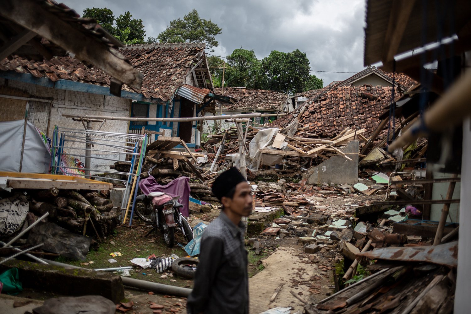 Warga mengamati bangunan rumahnya yang hancur akibat guncangan gempa bumi dengan magnitude 5.6 di Desa Mangunkerta, Cugenang, Cianjur, Jawa Barat, Sabtu (26/11). Badan Nasional Penanggulangan Bencana (BNPB) mencatat total 321 orang meninggal dunia, jumlah pengungsi hingga hari ini mencapai 73.874 orang akibat gempa di Cianjur.