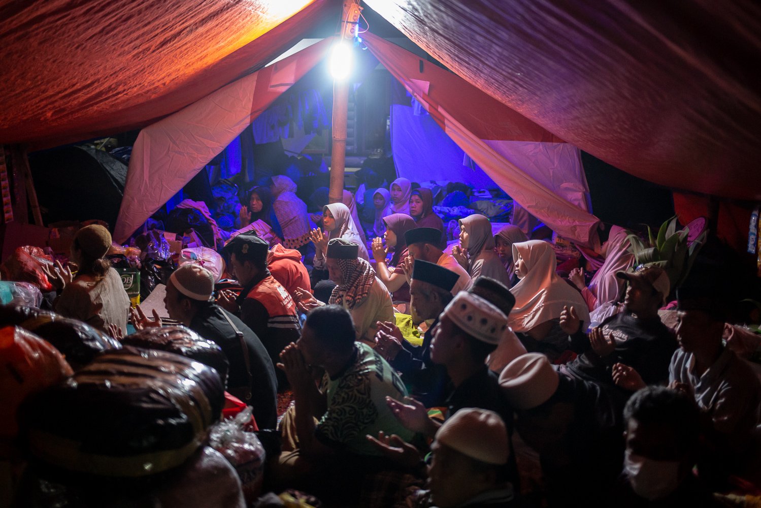Sejumlah pengungsi berdoa bersama di tenda pengungsian pasca gempa bumi dengan magnitude 5.6 di Desa Gasol, Cugenang, Cianjur, Jawa Barat, Minggu (27/11). Badan Nasional Penanggulangan Bencana (BNPB) mencatat total 321 orang meninggal dunia, jumlah pengungsi hingga hari ini mencapai 73.874 orang akibat gempa di Cianjur.
