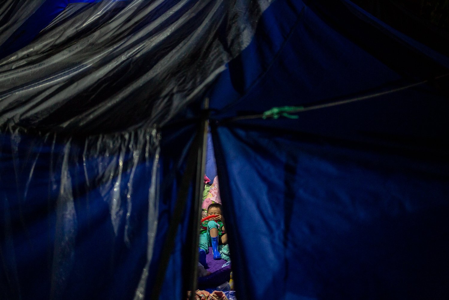 Seorang anak terlihat bermain di dalam tenda pengungsian pasca gempa bumi dengan magnitude 5.6 di Desa Mangunkerta, Cugenang, Cianjur, Jawa Barat, Minggu (27/11). Badan Nasional Penanggulangan Bencana (BNPB) mencatat total 321 orang meninggal dunia, jumlah pengungsi hingga hari ini mencapai 73.874 orang akibat gempa di Cianjur.