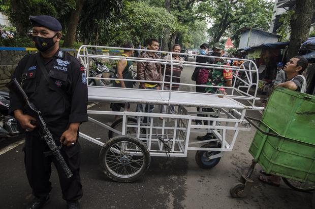 Tim Brimob Polri bersama warga menggunakan keranda mayat untuk menutup jalan usai peristiwa bom bunuh diri di Polsek Astanaanyar, Bandung, Jawa Barat, Rabu (7/12/2022). Pihak kepolisian masih terus menyelidiki dan mengamankan area lokasi bom bunuh diri.