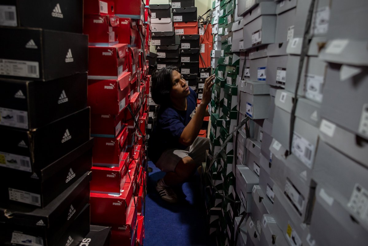 Pekerja mencari ukuran sepatu yang dibeli pengunjung di Urban Sneaker Society (USS) 2022 di Hall A dan B Jakarta Convention Center (JCC), Jakarta, Jumat (9/12). Acara tersebut digelar sebagai wadah bagi para pelaku usaha industri fesyen dan penikmatnya untuk saling berinteraksi.