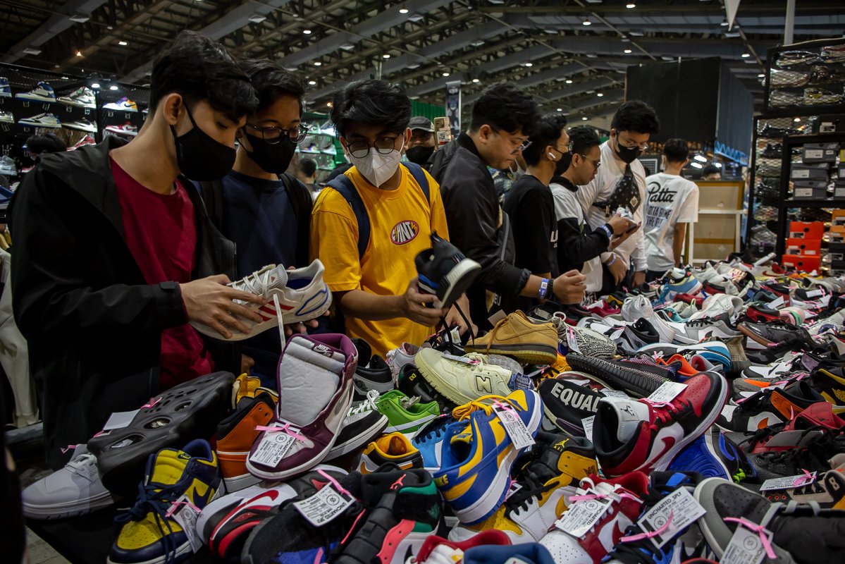 Pengunjung memilah sepatu yang dijual di salah satu tenant pada acara Urban Sneaker Society (USS) 2022 di Hall A dan B Jakarta Convention Center (JCC), Jakarta, Jumat (9/12). Acara tersebut digelar sebagai wadah bagi para pelaku usaha industri fesyen dan penikmatnya untuk saling berinteraksi.