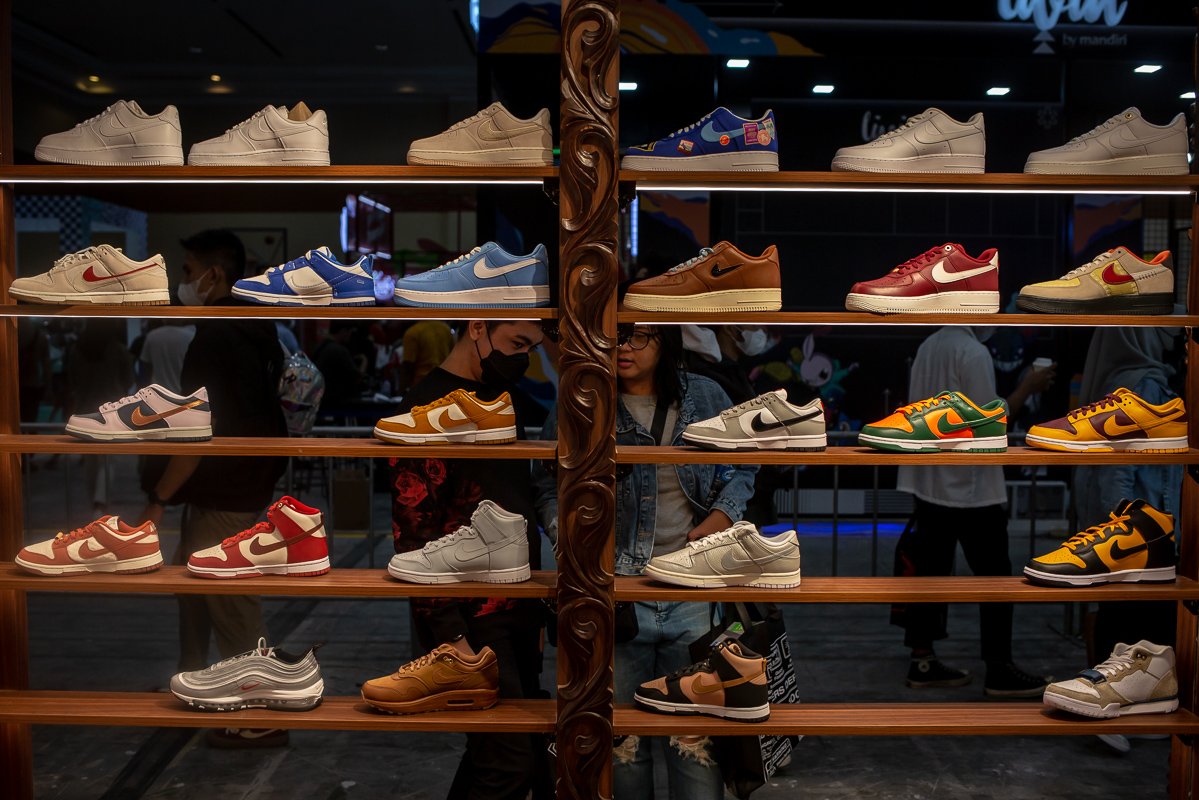 Pengunjung memilah sepatu yang dijual di salah satu tenant pada acara Urban Sneaker Society (USS) 2022 di Hall A dan B Jakarta Convention Center (JCC), Jakarta, Jumat (9/12). Acara tersebut digelar sebagai wadah bagi para pelaku usaha industri fesyen dan penikmatnya untuk saling berinteraksi.