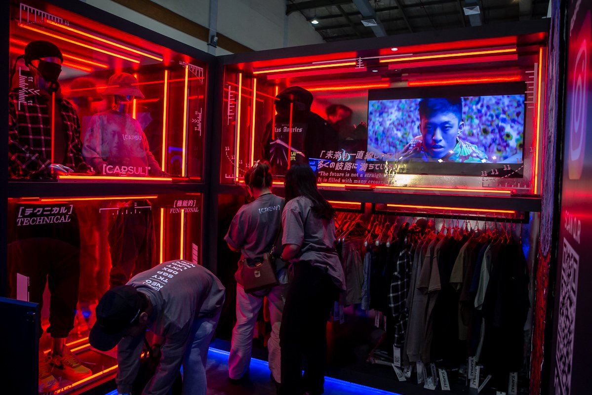 Pekerja menyiapkan pakaian yang akan djiual di salah satu tenant pada acara Urban Sneaker Society (USS) 2022 di Hall A dan B Jakarta Convention Center (JCC), Jakarta, Jumat (9/12). Acara tersebut digelar sebagai wadah bagi para pelaku usaha industri fesyen dan penikmatnya untuk saling berinteraksi.