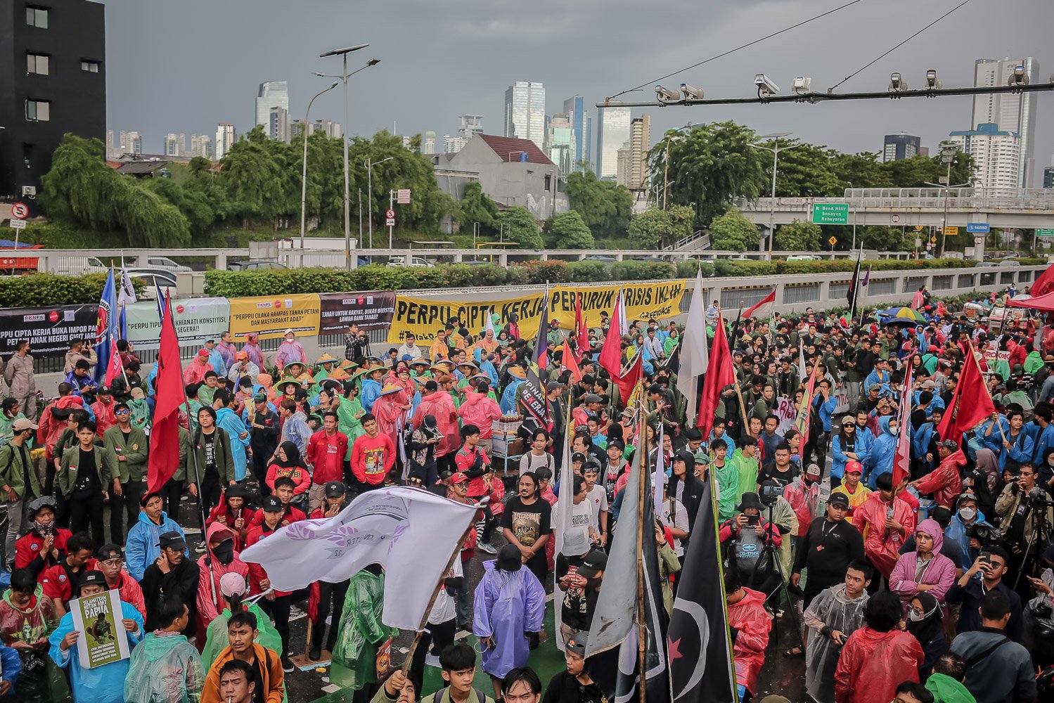 Massa yang tergabung dari beragam elemen masyarakat memadati area depan Gedung Dewan Perwakilan Rakyat, Senayan, Jakarta, Selasa (28/2). Mereka menggelar aksi unjuk rasa menolak Peraturan Pemerintah Pengganti Undang-Undang Cipta Kerja atau Perppu Ciptaker.