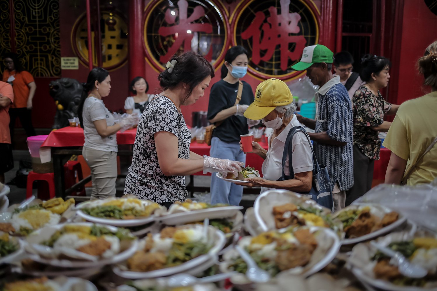 Pengurus vihara membagikan makanan berbuka puasa untuk warga di Vihara Dharma Bakti, Glodok, Jakarta, Rabu (29/3). Sebanyak 300 porsi makanan disediakan oleh pengurus Vihara Dharma Bakti untuk berbuka puasa bagi warga sekitar sebagai ajang mempererat persaudaraan umat beragama pada bulan Ramadan.