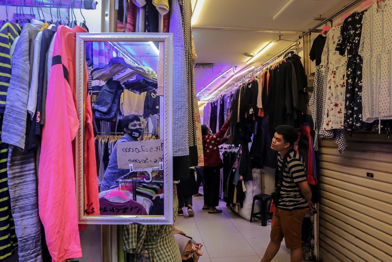 Penjual menunggu pembeli di salah satu toko di Pasar Senen, Jakarta, Kamis (30/3). Menteri Koperasi dan Usaha Kecil Menengah Teten Masduki menyampaikan telah memberikan solusi untuk pedagang pakaian bekas yang terdampak larangan \