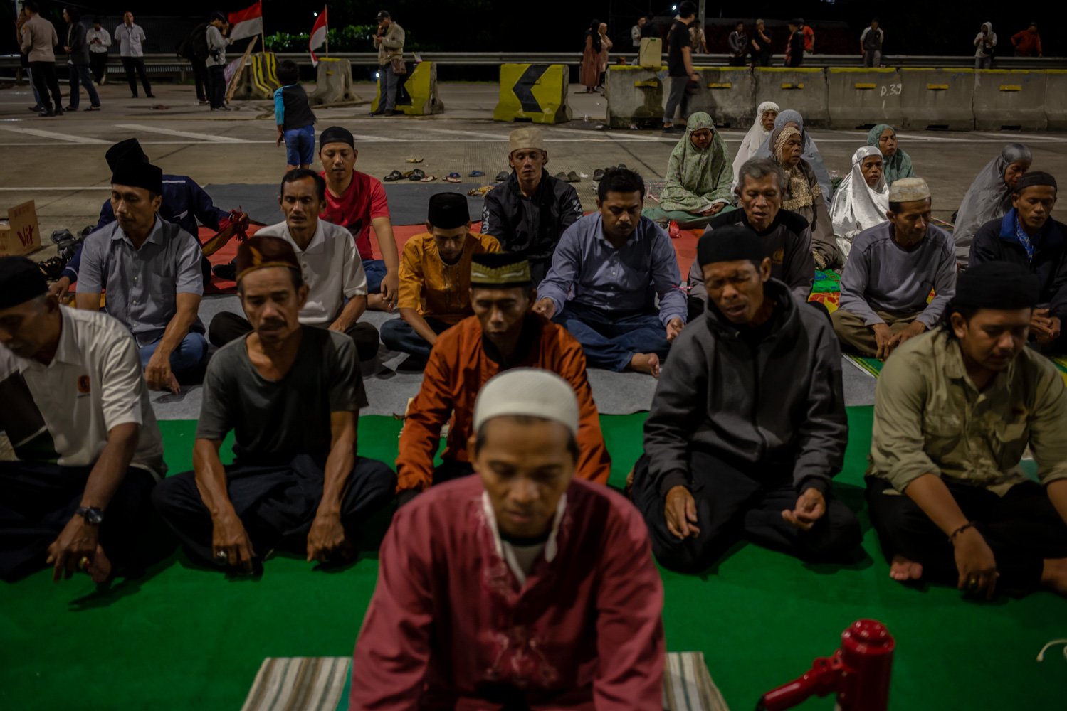 Sejumlah warga ahli waris melaksanakan Shalat Tarawih saat aksi penutupan Jalan Tol Jatikarya di Bekasi, Jawa Barat, Senin (10/4). Aksi penutupan jalan dari pukul 14.50 WIB tersebut menuntut pembayaran konsinyasi dari BPN (Badan Pertanahan Nasional) atas penggunaan tanah seluas 4,2 hektare untuk Tol Cimanggis-Cibitung di Jatikarya.