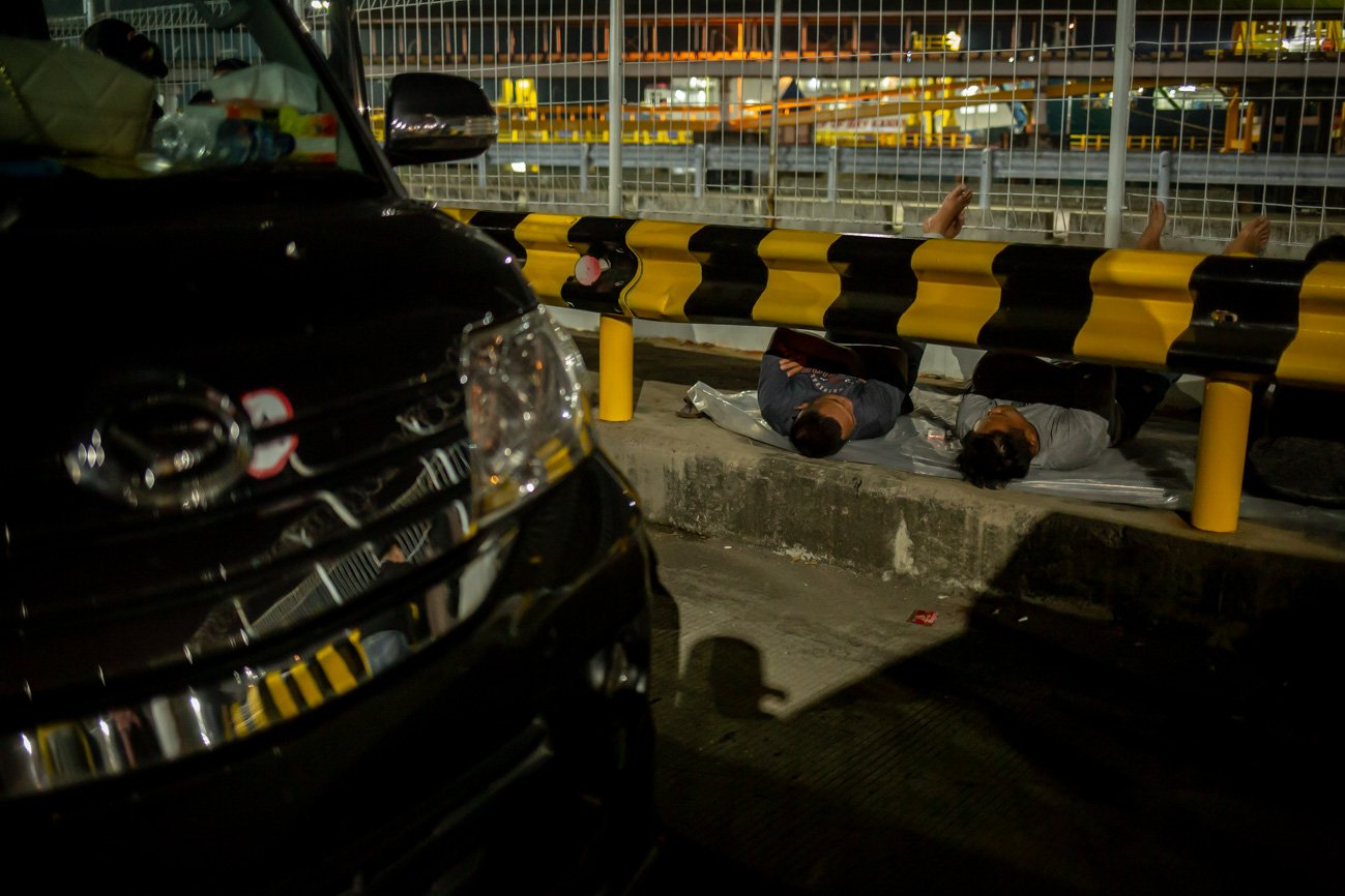 Pemudik tertidur saat menunggu antrean mobil di Pelabuhan Merak, Banten, Kamis (19/4) dini hari. Area parkir di tujuh dermaga yang tersedia di Plebuhan Merak sejak pukul 22.00 WIB, kembali dipenuhi mobil yang didominasi kendaraan pribadi.