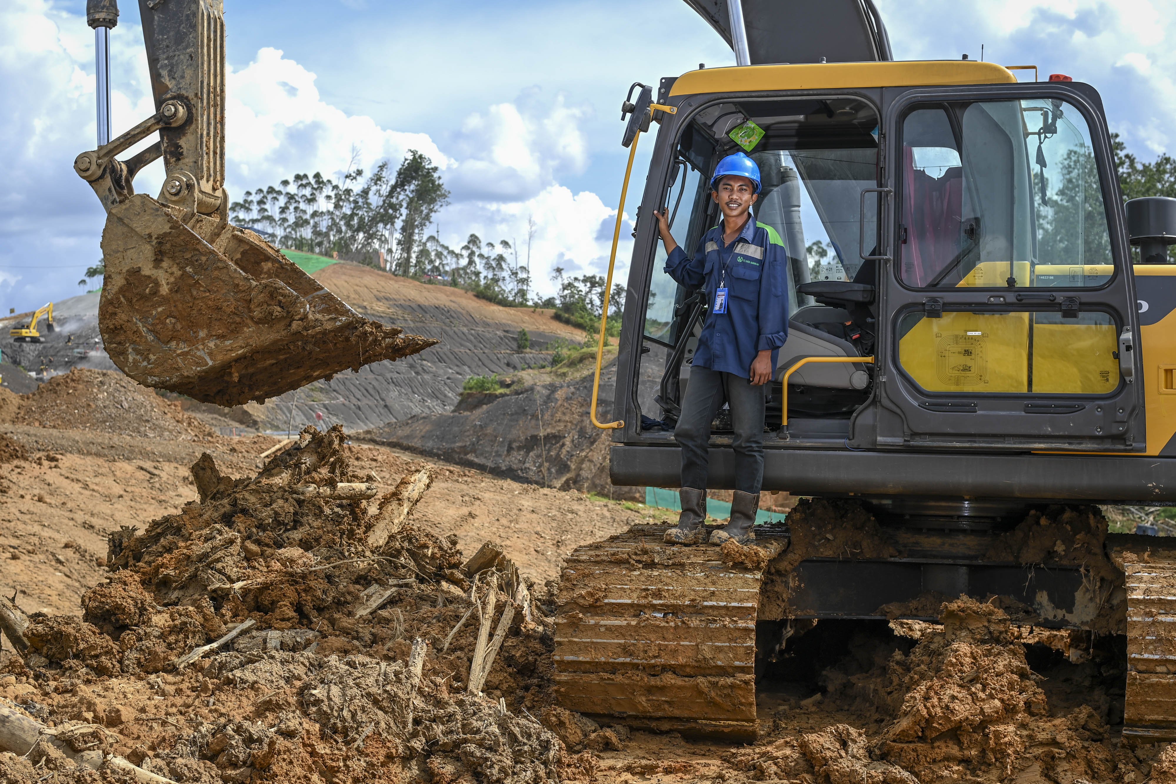 Operator excavator asal Balikpapan Rahman Maulana (20) berpose di atas alat kerjanya di salah satu lokasi proyek Ibu Kota Nusantara, Penajam Paser Utara, Kalimantan Timur.