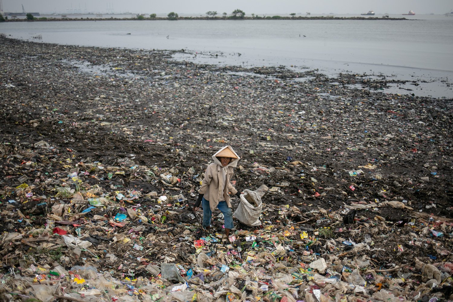 Warga memilah sampah plastik di atas tumpukan sampah di sekitar Pantai Marunda, Cilincing, Jakarta, Kamis (8/6).Dalam peringatan Hari Laut Internasional kondisi laut Jakarta masih dipenuhi sampah. Menurut KLHK Indonesia menghasilkan lebih dari 19 juta ton sampah sepanjang 2022, 18 persennya sampah plastik yang sebagian ngalir ke laut.