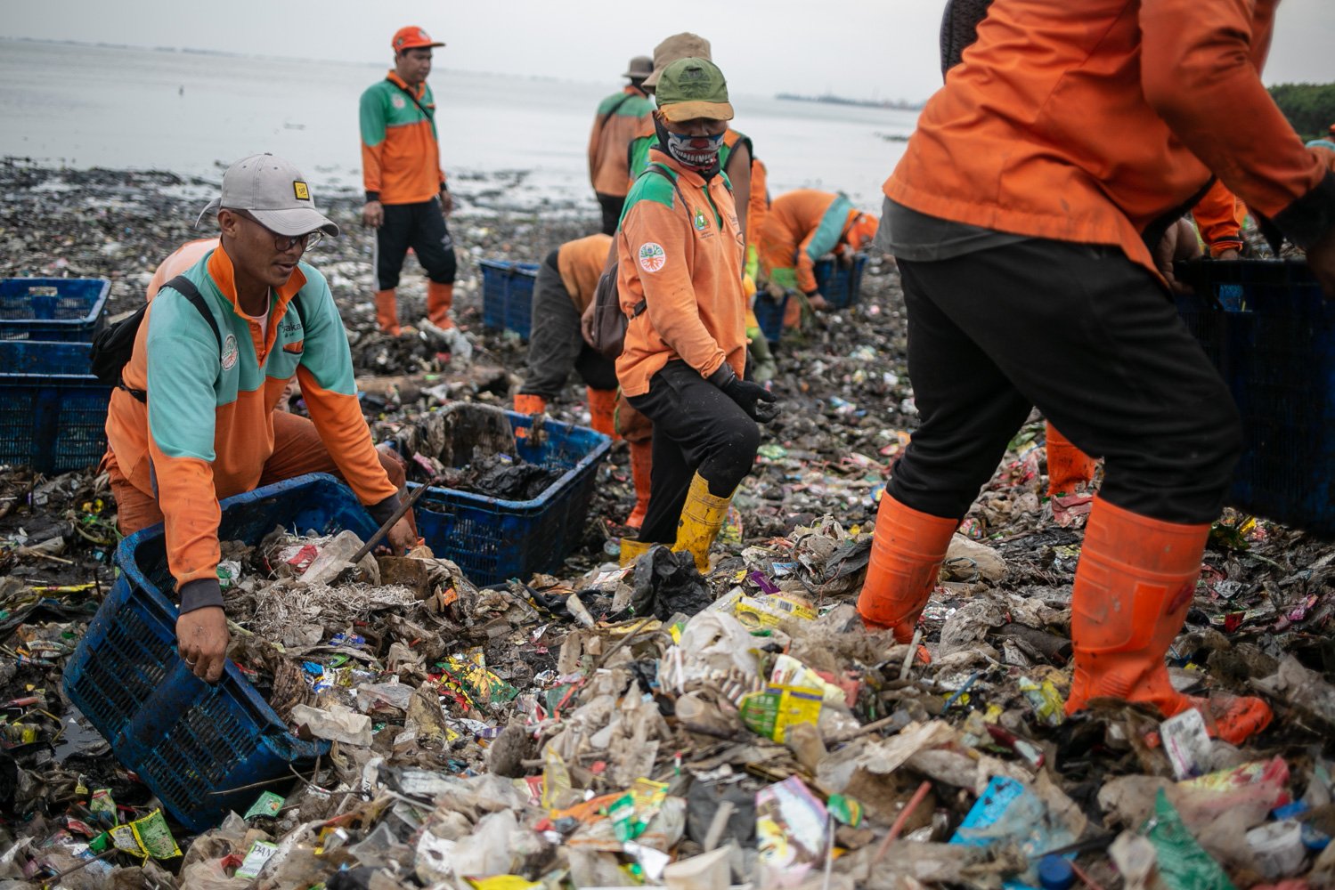 Petugas Penanganan Prasarana dan Sarana Umum (PPSU) mengumpulkan sampah di sekitar Pantai Marunda, Cilincing, Jakarta, Kamis (8/6). Dalam peringatan Hari Laut Internasional kondisi laut Jakarta masih dipenuhi sampah. Menurut KLHK Indonesia menghasilkan lebih dari 19 juta ton sampah sepanjang 2022, 18 persennya sampah plastik yang sebagian ngalir ke laut.
