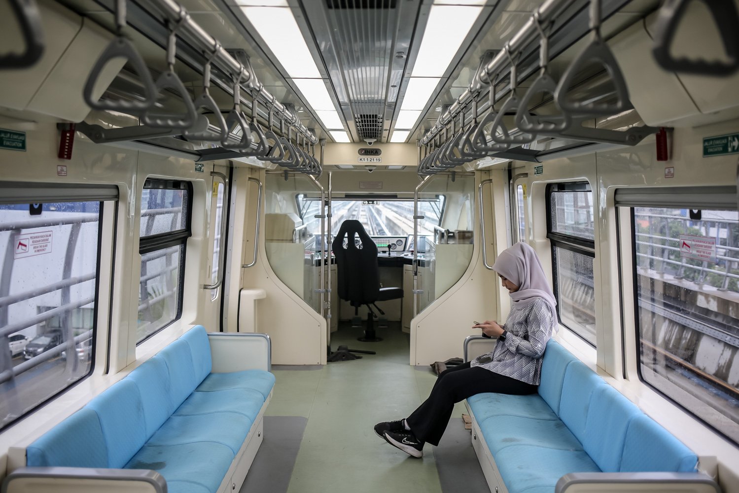 Wartawan duduk di gerbong kereta Lintas Rel Terpadu (LRT) saat melintasi perlintasan LRT Cikoko, Jakarta, Kamis (6/7). LRT Jabodebek akan dioperasikan dengan sistem berbasis komunikasi sehingga dapat dioperasikan dari pusat kendali dan tanpa masinis.
