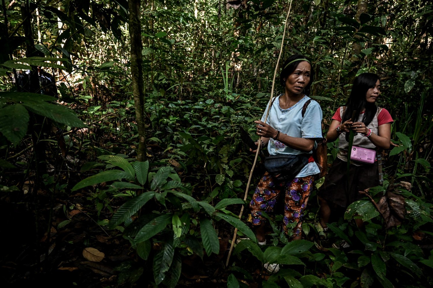 Ngakokup (kiri), dan anaknya Siti berjalan menyusuri kawasan hutan saat berburu.