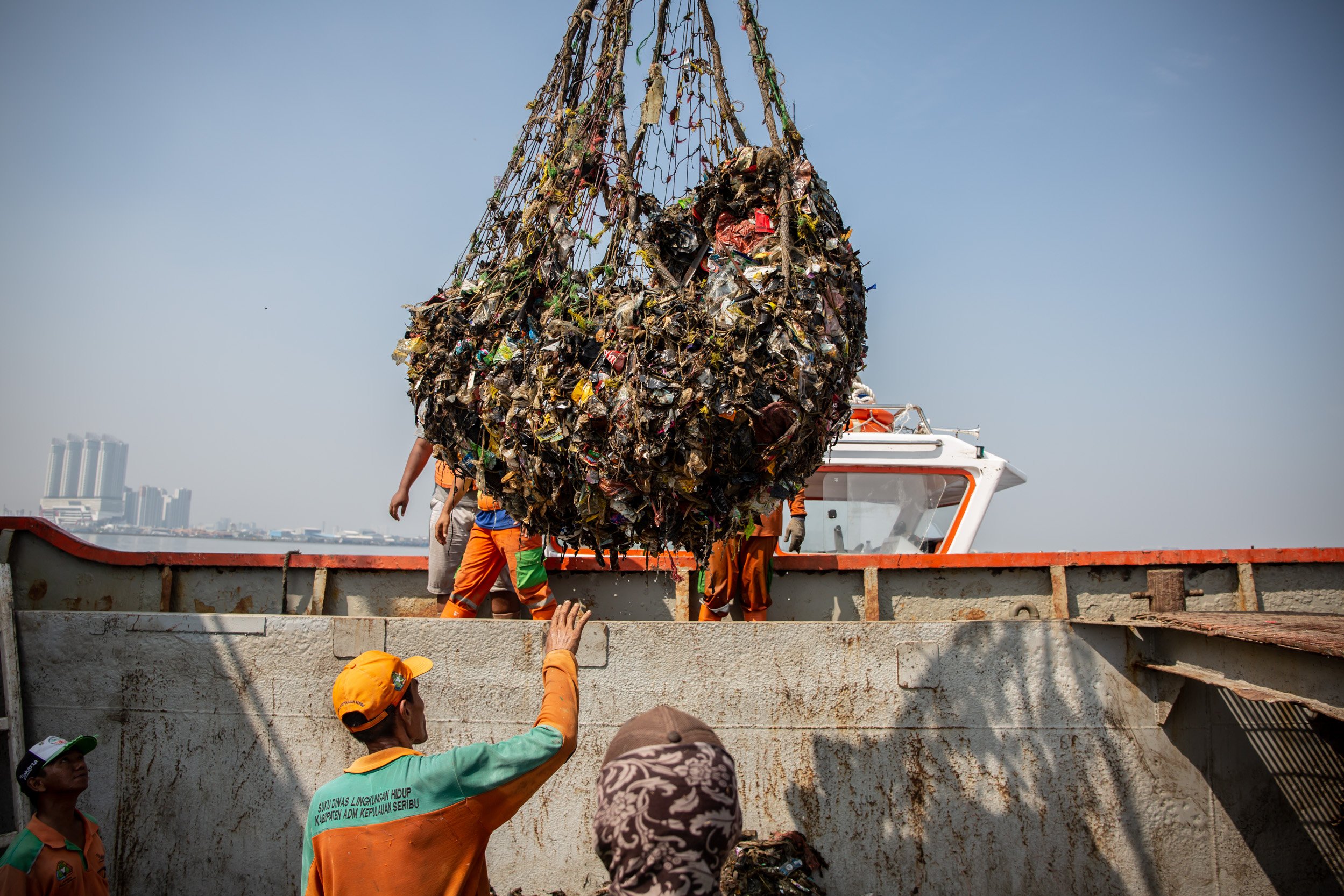 Petugas Penanganan Prasarana & Sarana Umum (PPSU) bersama Dinas Lingkungan Hidup DKI Jakarta memindahkan sampah ke kapal besar saat membersihkan sampah yang menumpuk di hutan mangrove Muara Angke, Penjaringan, Jakarta Utara, Jumat (13/7). Berdasarkan hasil penelitian BRIN, sampah yang terperangkap di Hutan Mangrove Muara Angke bersumber dari wilayah yang tidak jauh dari kawasan mangrove tersebut.
