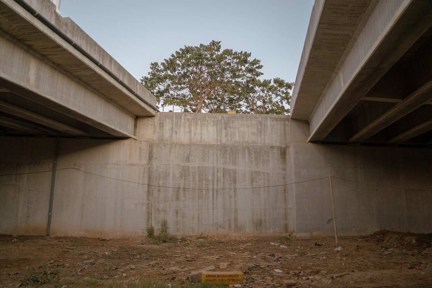 Sejumlah pohon terlihat dari bawah kolong jembatan di Jalan Pipa Kampung Muara, Teluknaga, Tangerang, Selasa (1/8). Jalan ini merupakan satu-satunya akses masyarakat untuk keluar masuk Kampung Muara.