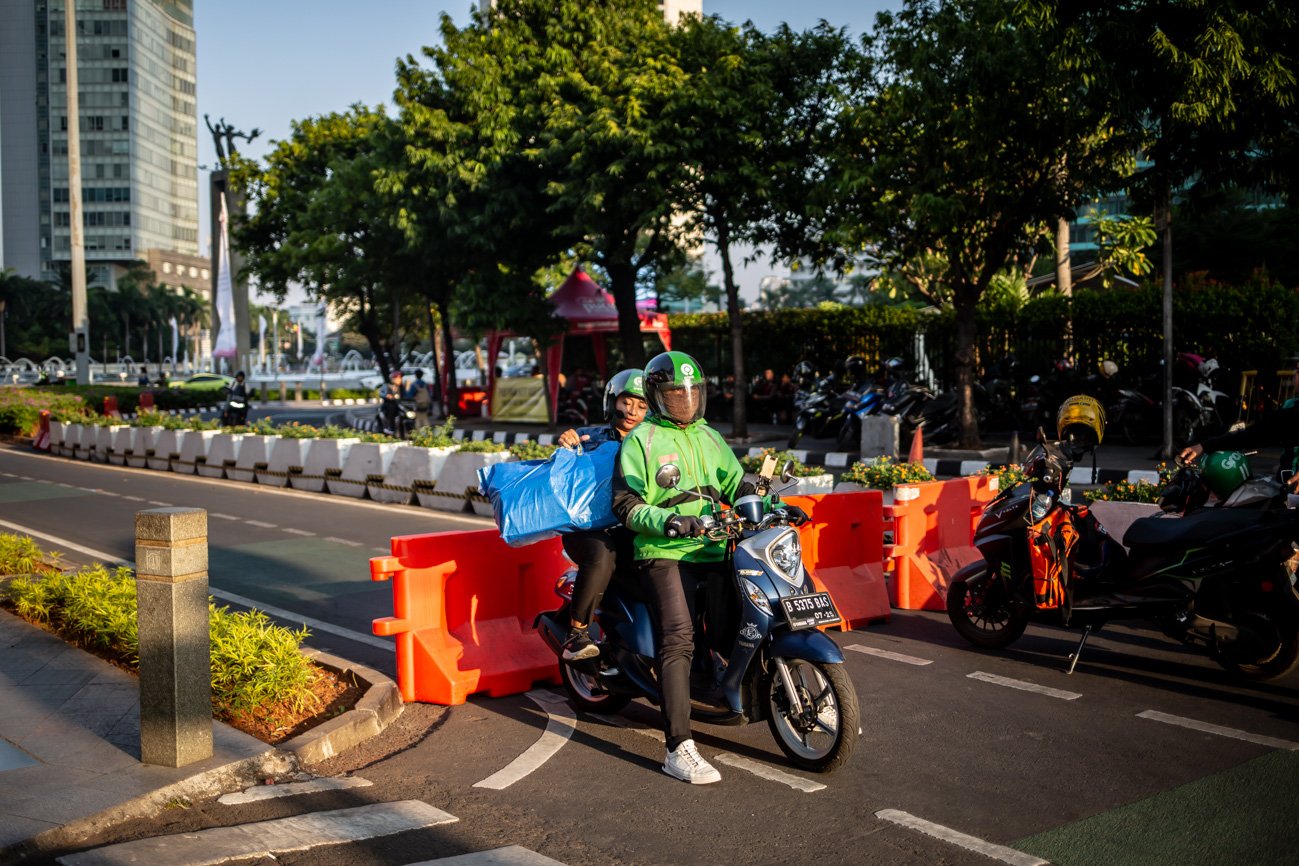 Pengendara ojek online mengangkut penumpang di jalan yang dibatasai water barrier saat rekayasa lalu lintas di kawasan Bundaran HI, Jakarta, Selasa (5/9). Sejumlah rekayasa lalu lintas diberlakukan dalam rangka mendukung penyelenggaraan KTT ASEAN sejak tanggal 2 September, hingga puncak resminya 5-7 September 2023.