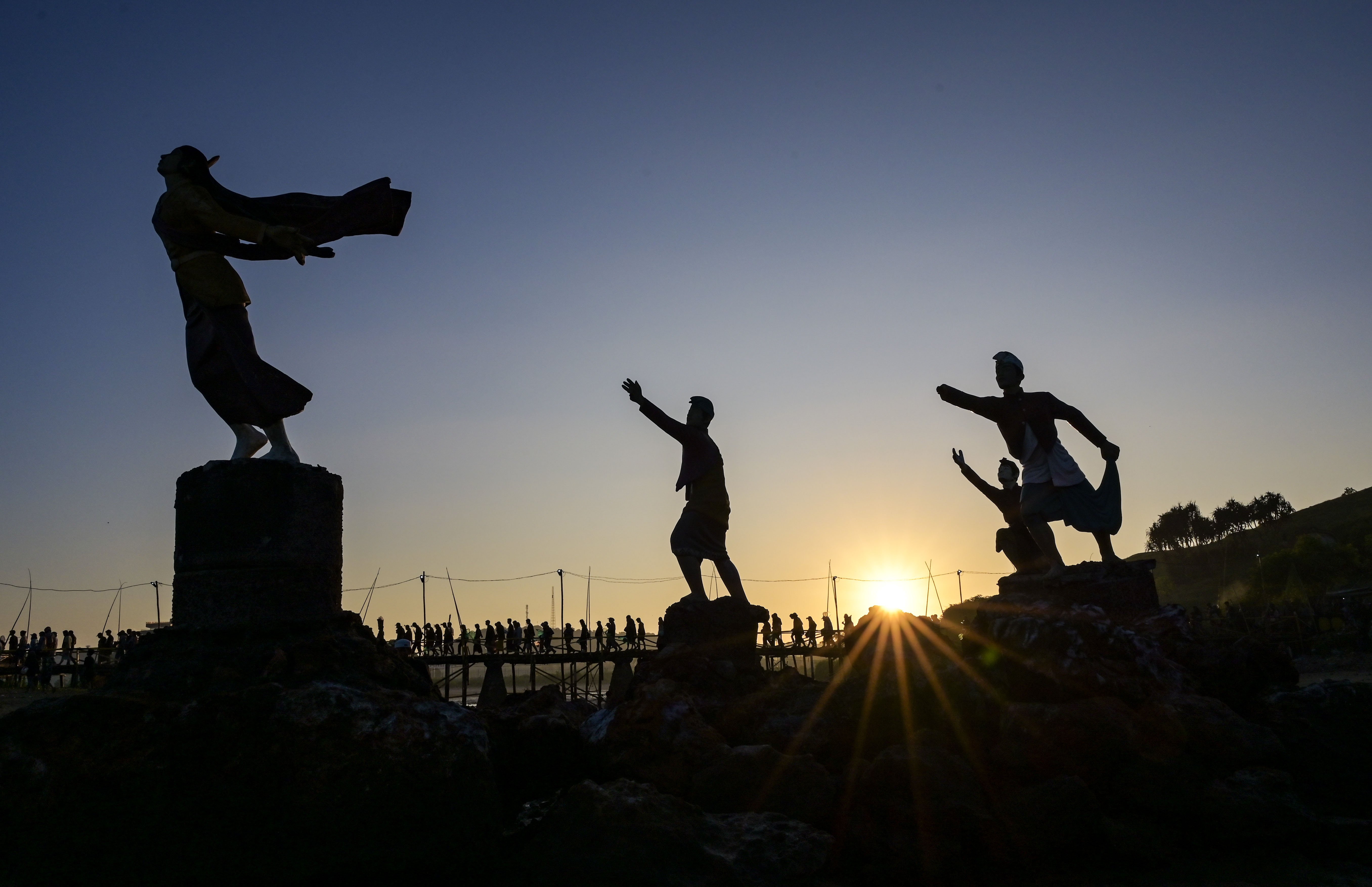 Sejumlah warga melintas dekat patung Putri Mandalika usai mengumpulkan nyale (cacing laut warna-warni) pada Festival Pesona Bau Nyale 2024 di Pantai Seger Kawasan Ekonomi Khusus (KEK) Mandalika, Kuta, Praya, Lombok Tengah, NTB.