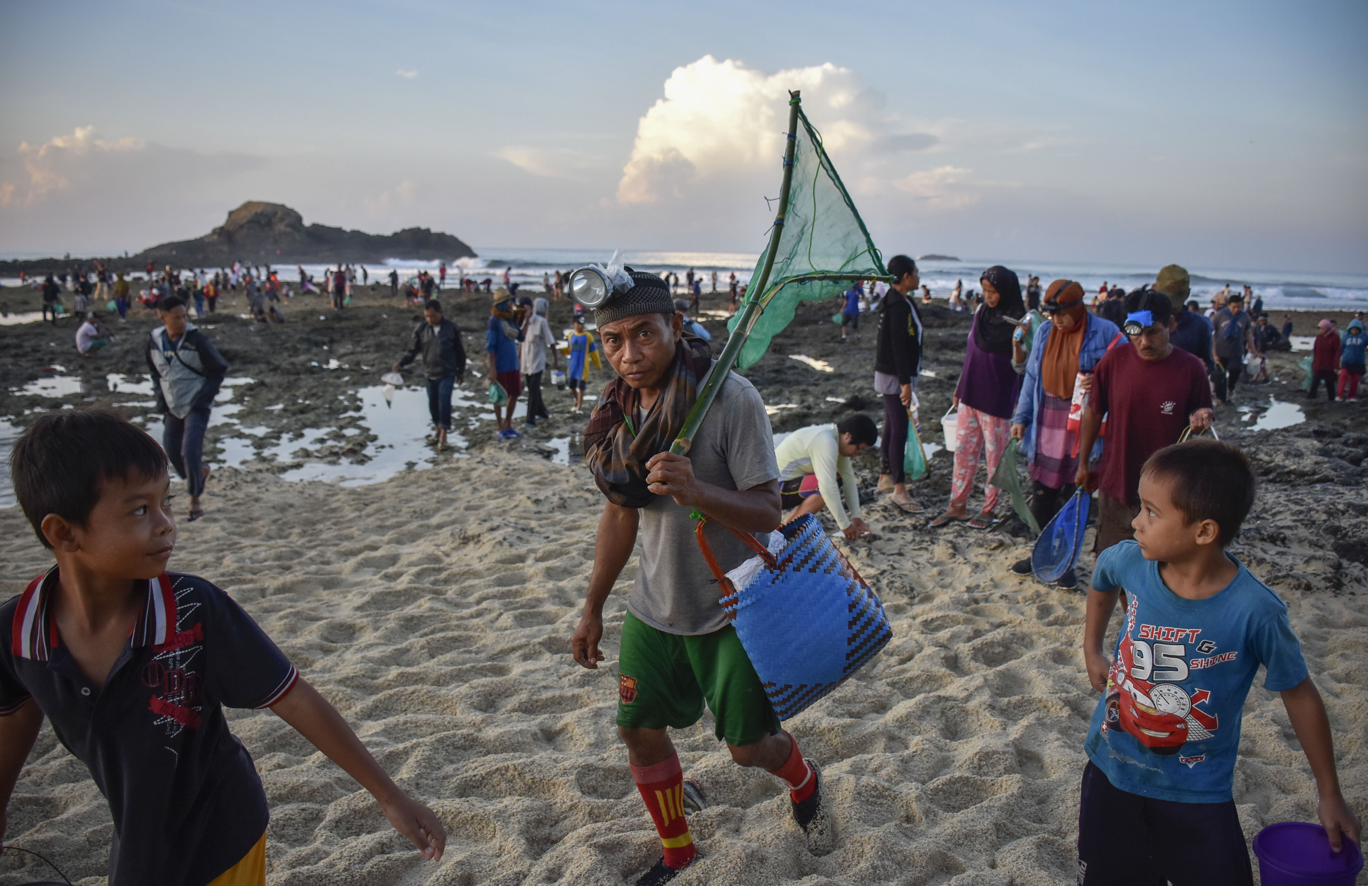 Sejumlah warga berjalan pulang usai menangkap nyale (cacing laut warna-warni) pada tradisi Bau Nyale di Pantai Seger Kawasan Ekonomi Khusus (KEK) Mandalika, Kuta, Praya, Lombok Tengah, NTB.